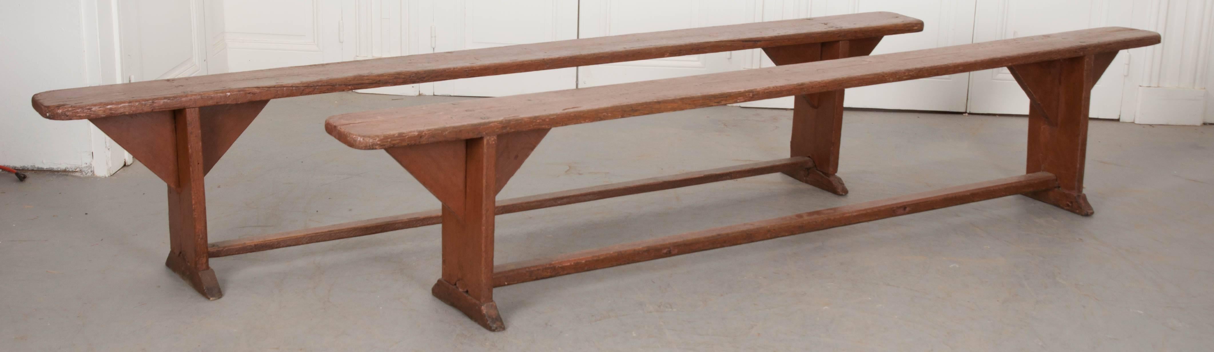 A handsome pair of pine benches from 19th century England. These wonderful benches have exceptional patina, with evidence of much use through the years. The pair could be used in lieu of dining chairs for one or both sides of a dining table. They