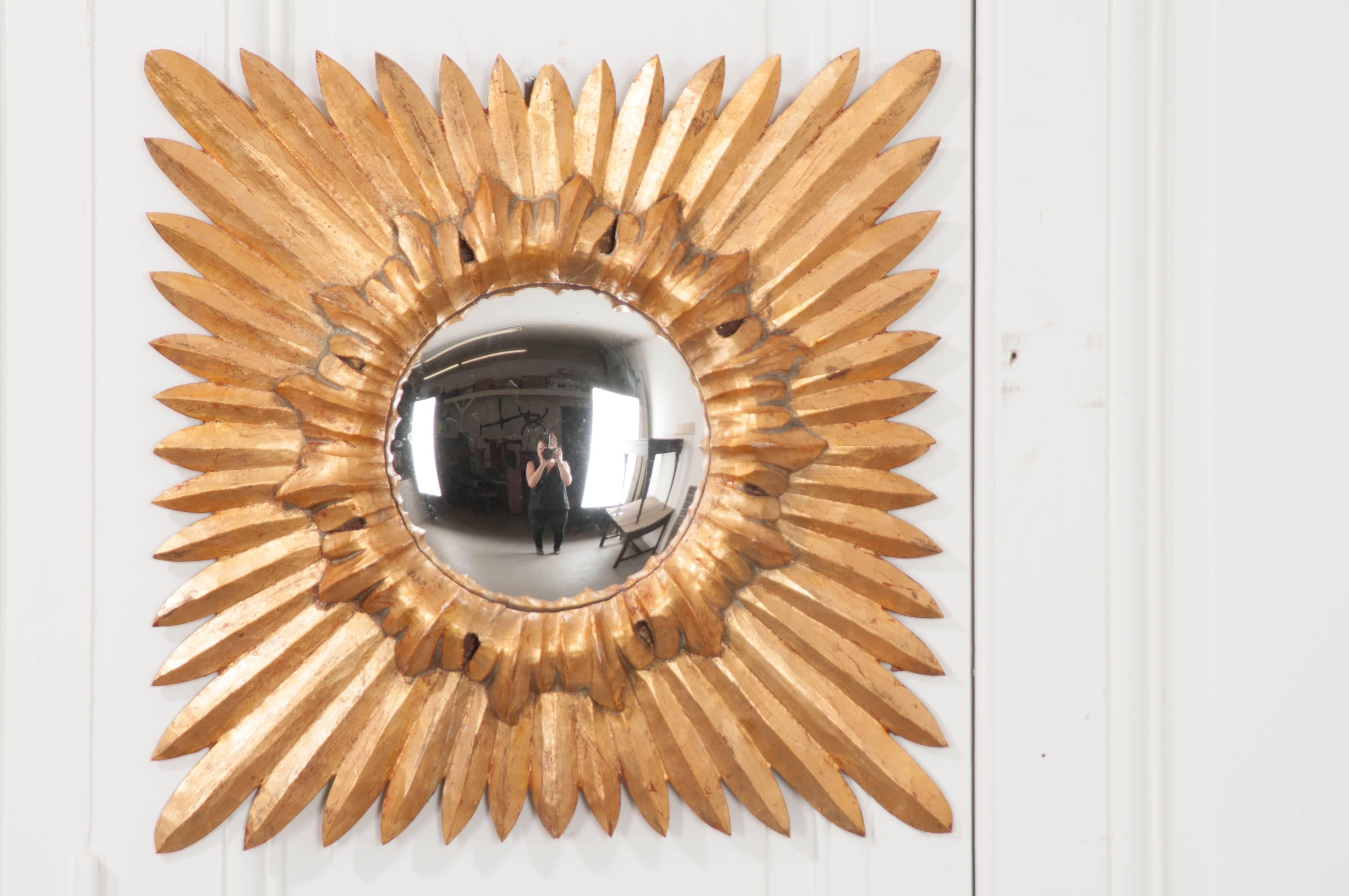 An exceptional gold gilt starburst mirror with convex glass from 19th century, France. Long gilt rays extend from behind the bulging circular mirror that has been encircled with beautifully carved gilt trim. This spectacular splash of gold would be