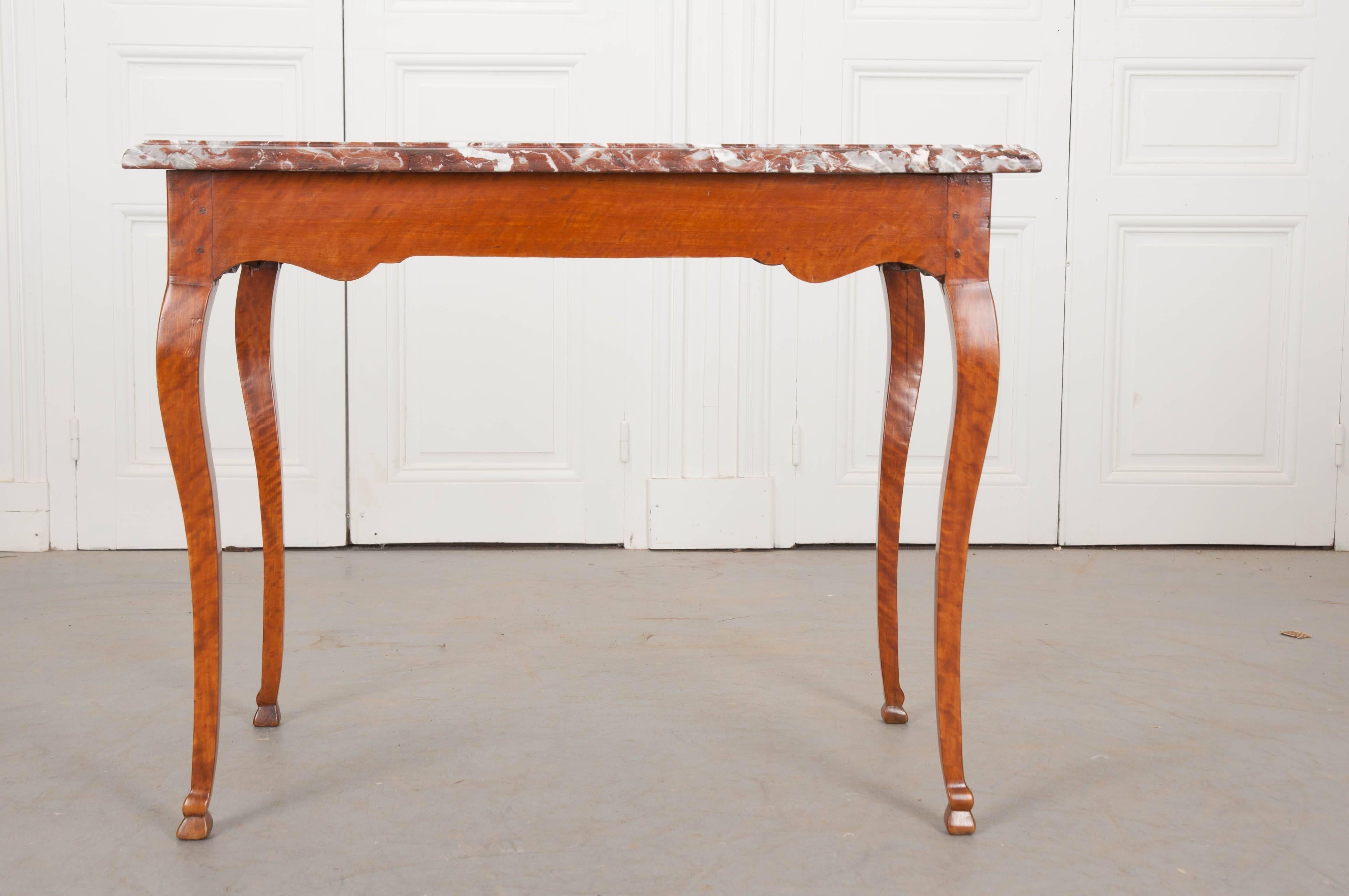 A breathtaking birch writing table, made at the beginning if the 19th century in France. The marble top is a rich cinnamon color, with vibrant flashed of white throughout, and a wonderful finished edge. The base is made of solid birch with beautiful