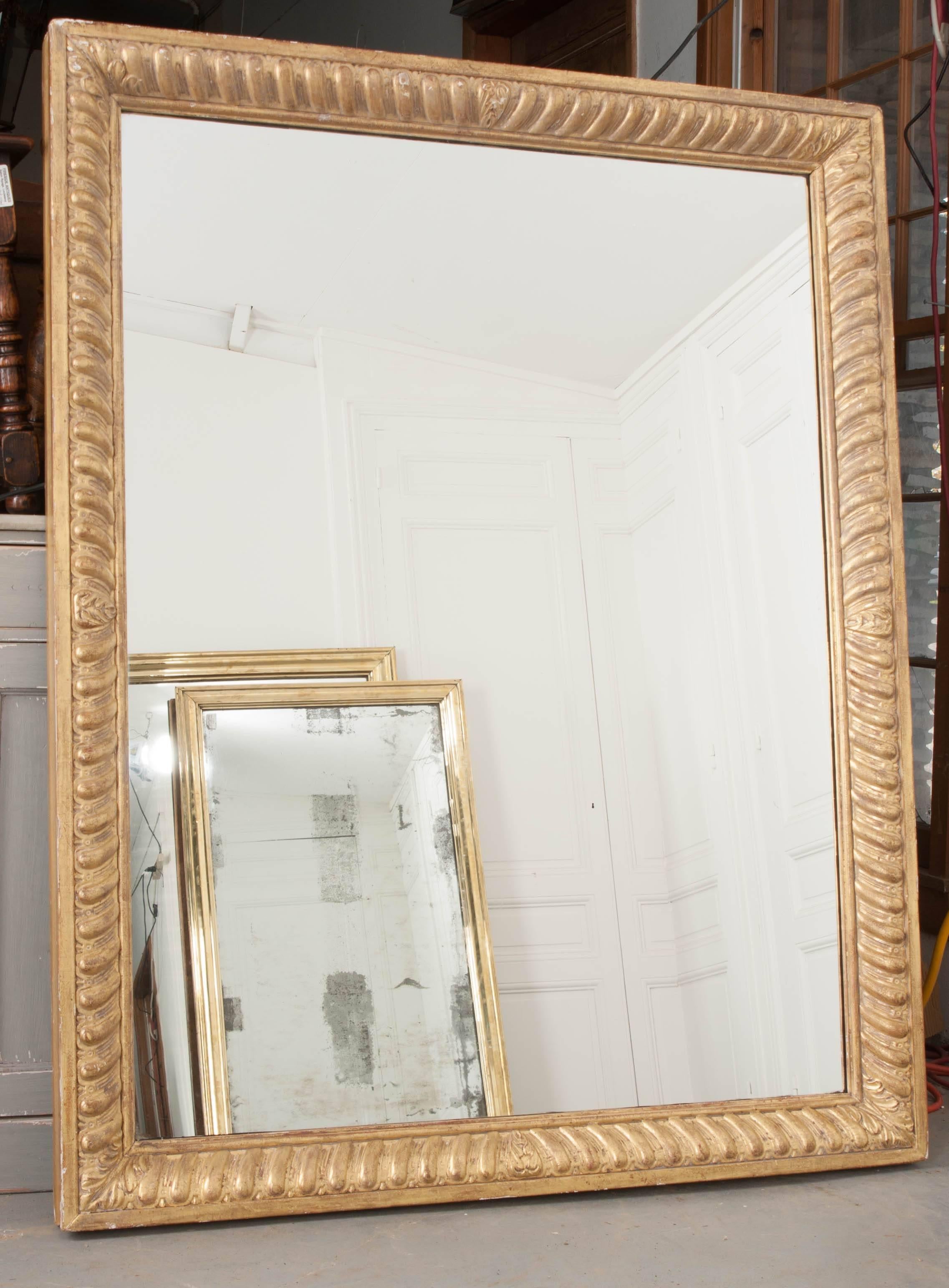 A size-able gold gilt wall mirror from France, circa 1880. This wonderful antique has a gilt frame styled with a mirrored, or book-matched motif done in a classic styling. The gold gilt is in wonderful antique condition, with brilliant color and