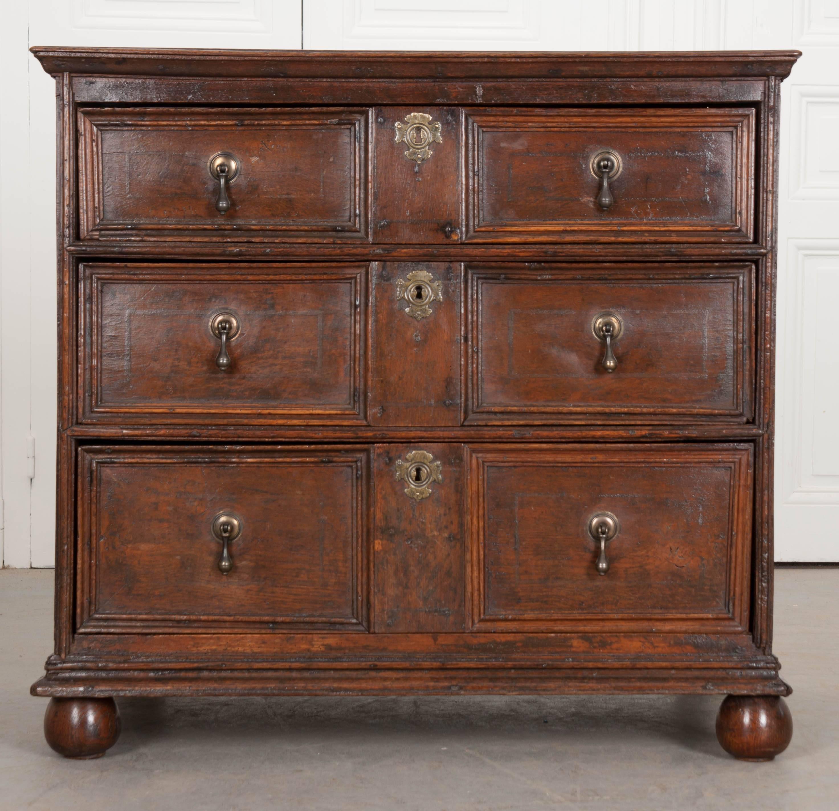 A handsome three-drawer Jacobean oak chest, made in England, circa 1720. This nearly three hundred year old antique chest is in amazing antique condition, with a rich, deep color expressed in the oak and the classic linear design that is found in