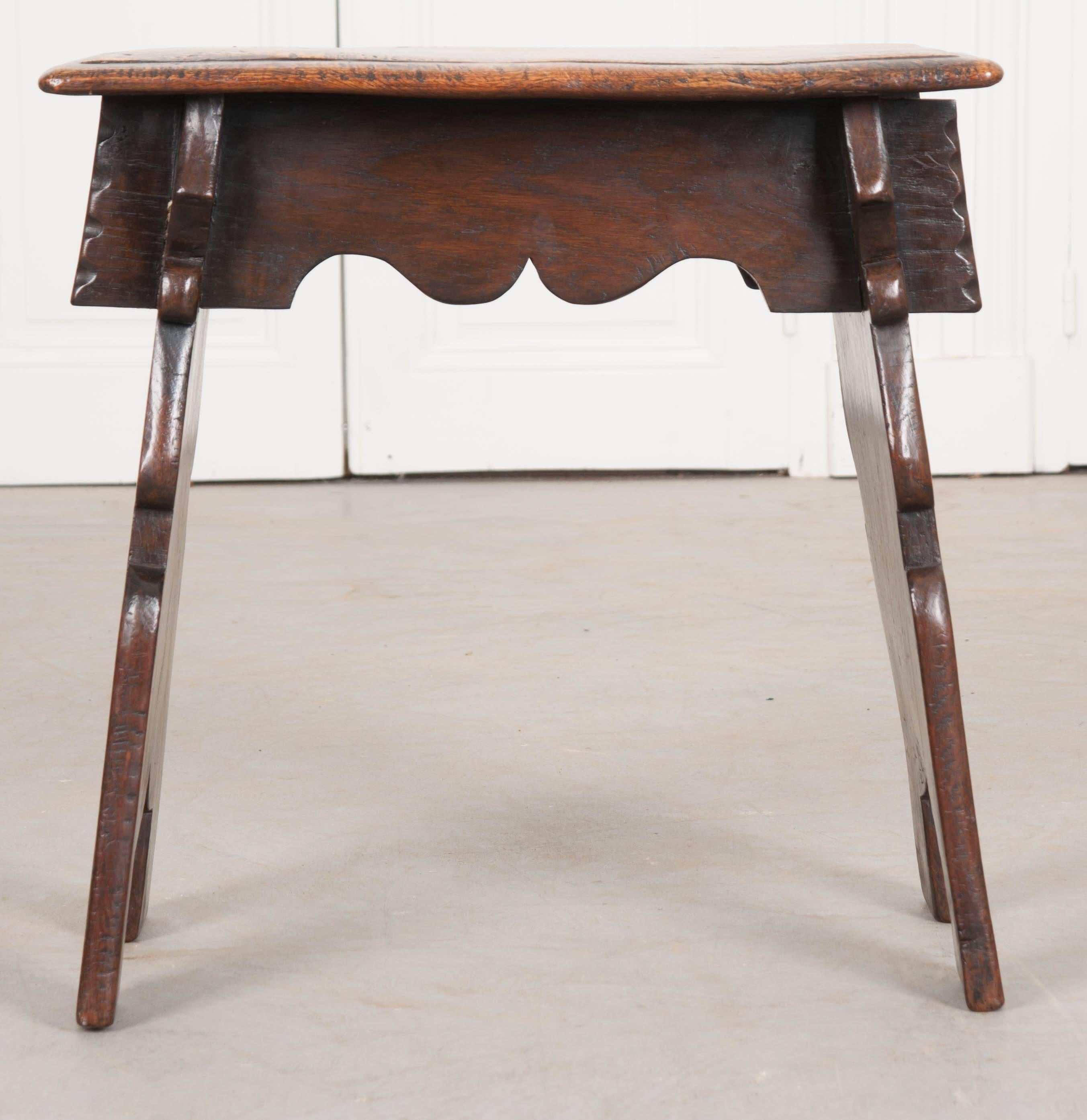 A spectacular oak joint stool from 1900s England. This stool features excellent patina from years of use as well as unique, shaped buttresses that support anyone seated. These low stools can be used for many purposes and make wonderful decorative