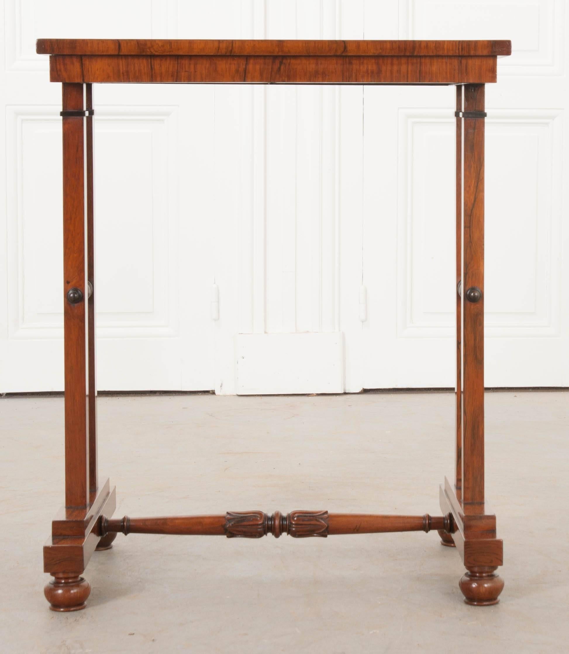 A sweet little George IV library table, done in rosewood, from early 19th century England. This fantastic table features a book-matched rosewood veneer top that is in excellent antique condition. The top is lifted by four linear legs. The legs are