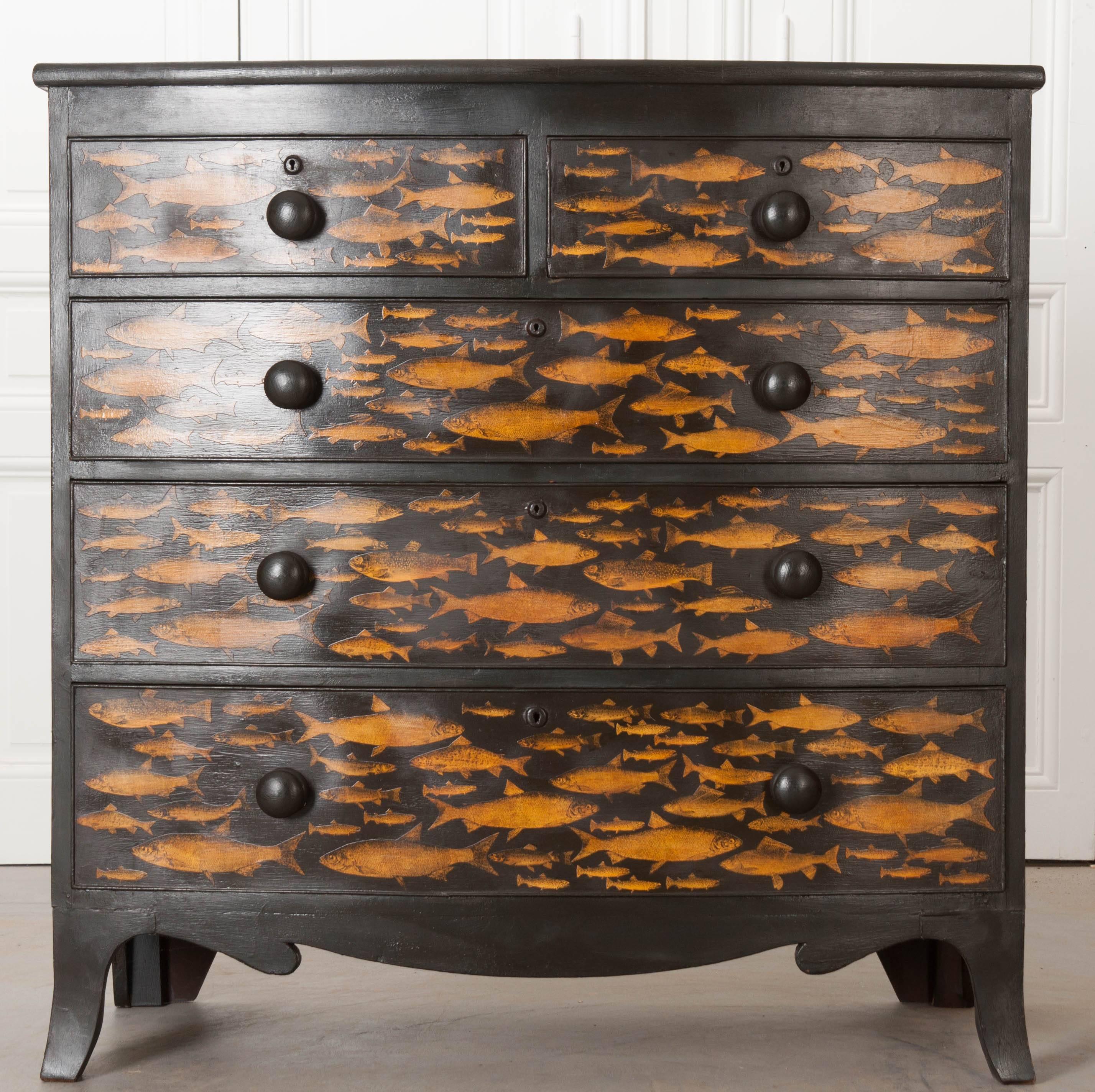 A bow-front, découpage and painted five-drawer chest of drawers from 19th century England. The chest has more recently had wonderful gold fish decoupaged onto the piece. Each drawer has turned, wooden knobs that have also been painted black. The