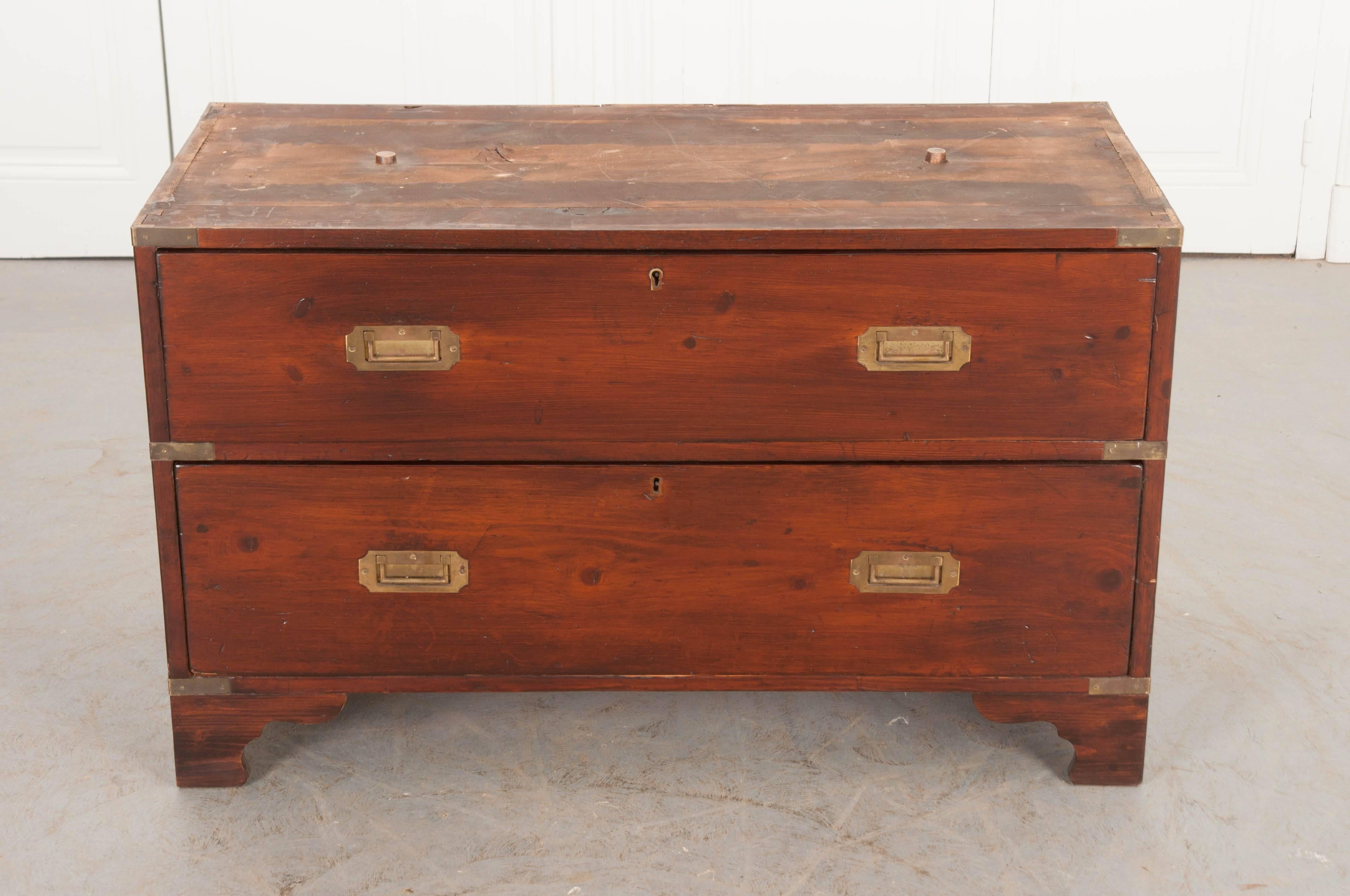 An antique English military style Campaign chest of drawers that is extremely handsome, with a refined and confident stance. Campaign chests often break down into two or more pieces, allowing for easier transportation. This five-drawer chest breaks