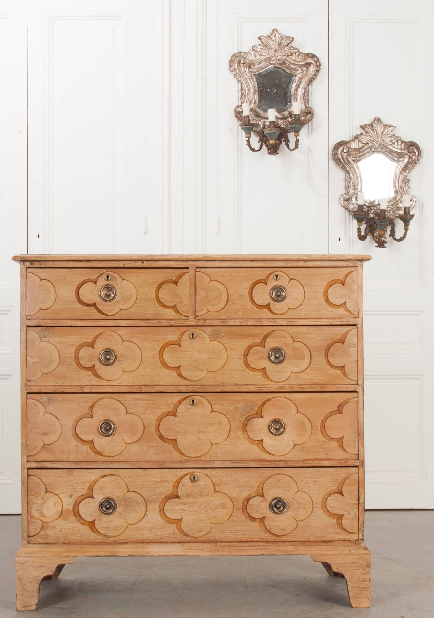 A delightful painted pine chest of drawers, made in England circa 1860. This five-drawer chest has been painted with sweet clovers, done in a rusty sepia tone, over a mellow, antiqued yellow. The topmost drawers are half the size of the lower three