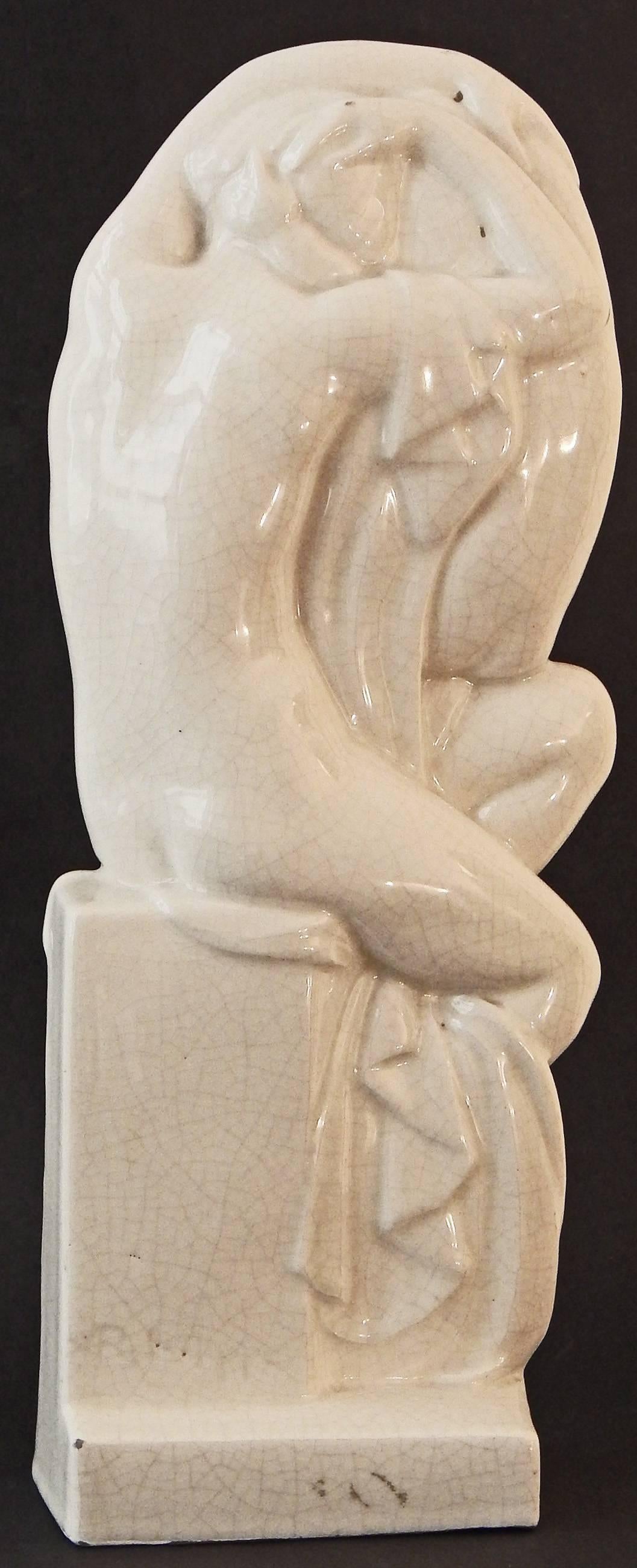 Unusually large and lovely, this ceramic sculpture by R. Philippe depicts a mother with child on her knee, with the arms of the two figures entwined, serving as a kind of Art Deco aureole hovering overhead. Philippe is known for his lithe, elegant