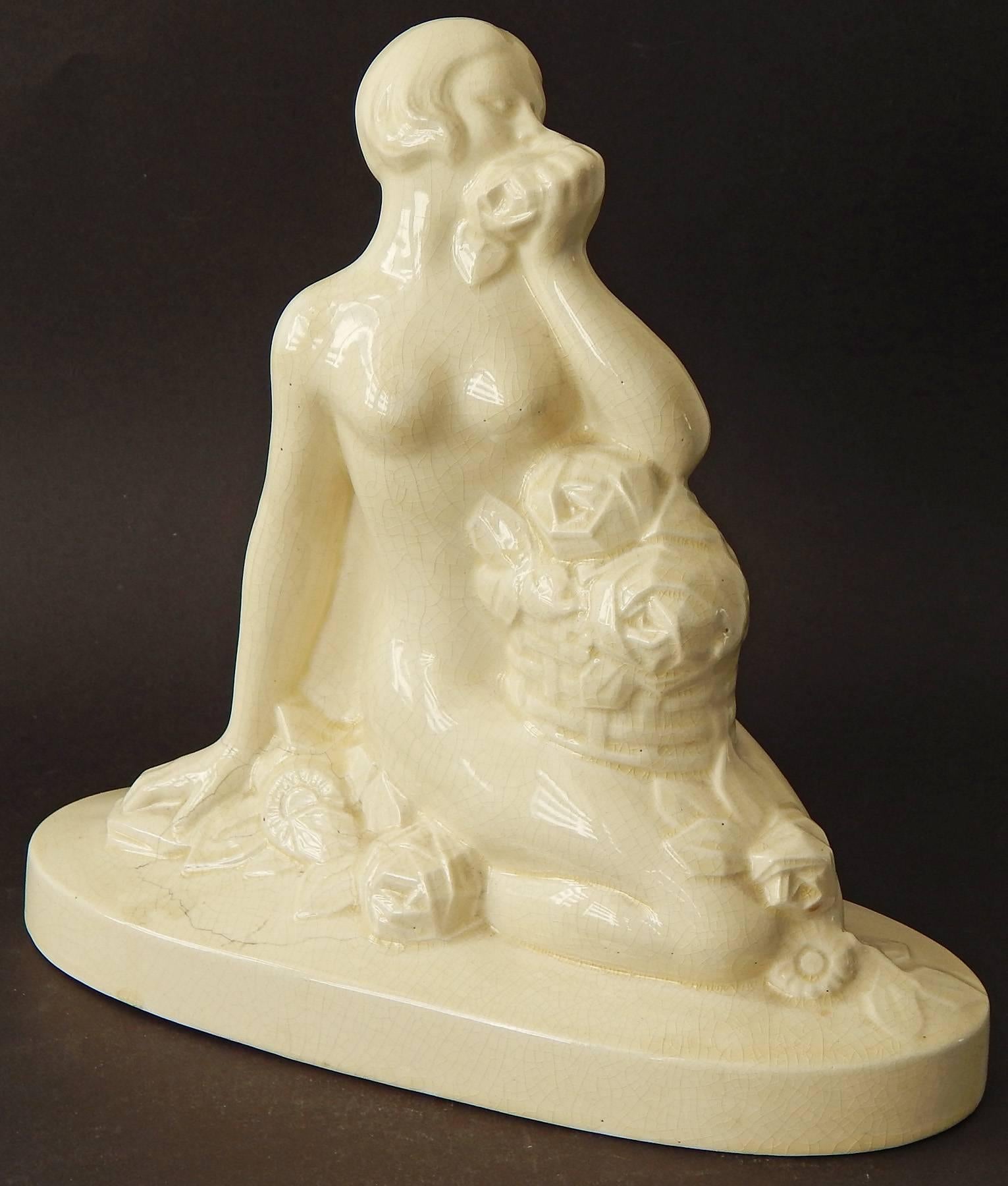 With a basket of roses in her lap, more roses at her feet, and another at her nose, this lovely sculpture of a female nude with a very modern hair style is a classic example of Art Deco design. The sculpture was produced by the famed Onnaing