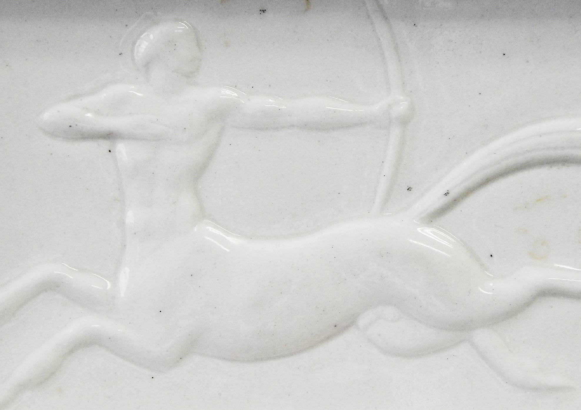 This dish or ashtray, perhaps unique, is a classic example of Art Deco design, and features a racing centaur figure, letting loose an arrow behind him, all enrobed in a lovely pale ivory-hued glaze over porcelain. The sculptor was Wheeler Williams,