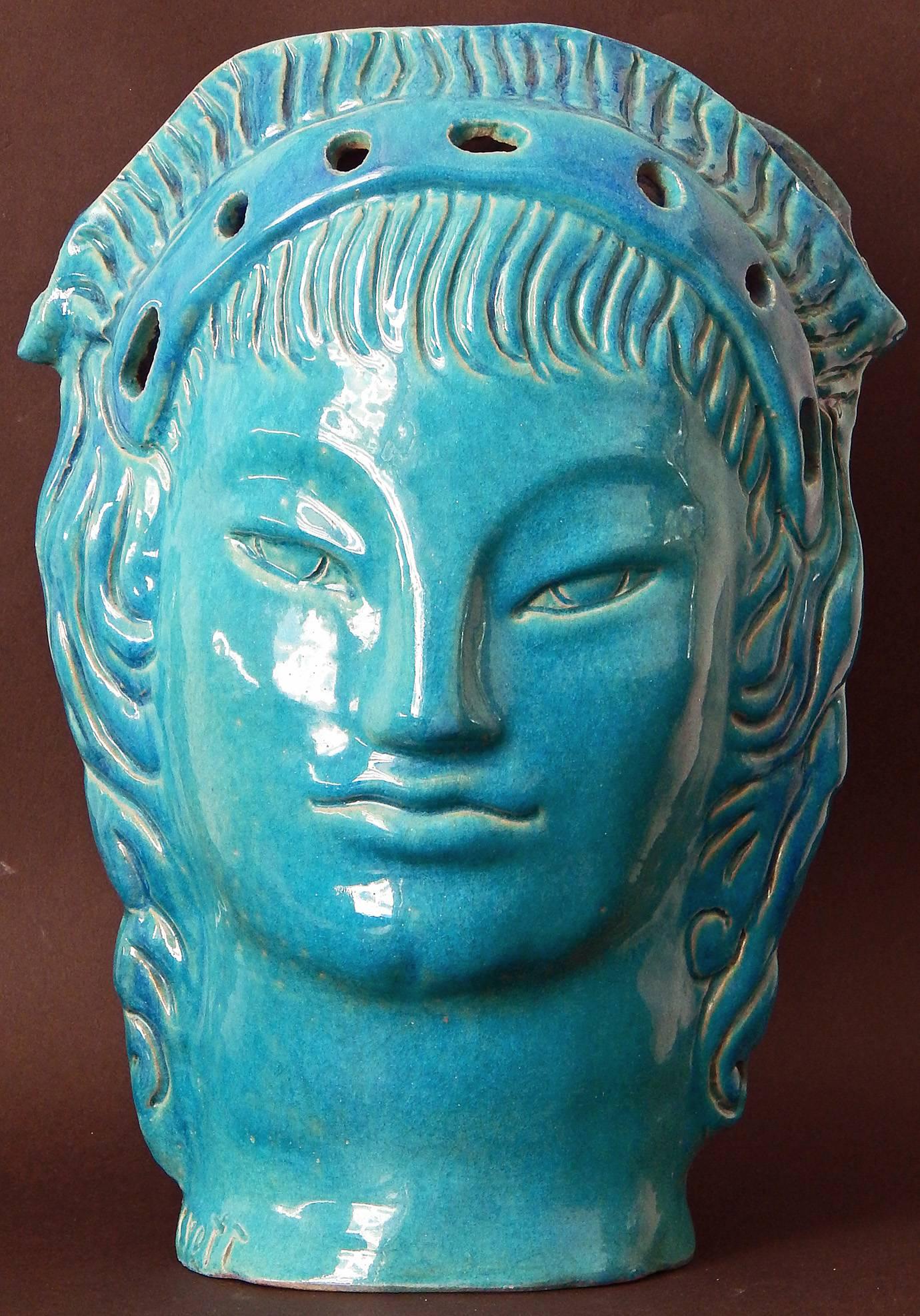 Bathed in a lovely Mediterranean blue glaze, and featuring two sculpted female heads on either side, this striking Art Deco vase was made by Edith Varian Cockcroft, a New York artist who studied with Henri Matisse. Cockcroft spent considerable time