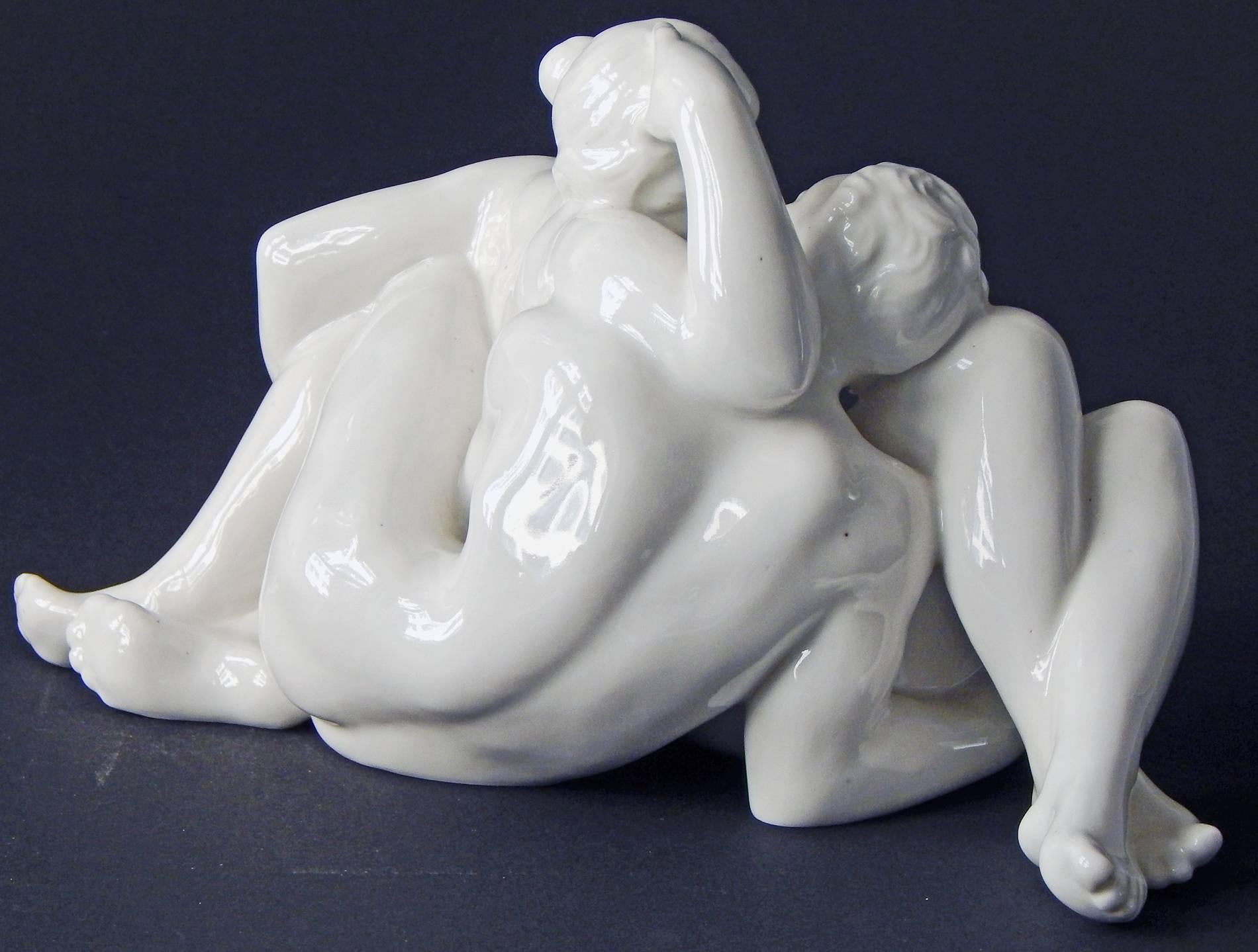 Sculpted by Jens Jakob Bregnoe for the famed Danish sculptor and porcelain designer, Jens Peter Dahl-Jensen, this rare piece depicts a nude male and female intertwined couple that is about to kiss. The figure is fully glazed in a glossy, liquidy
