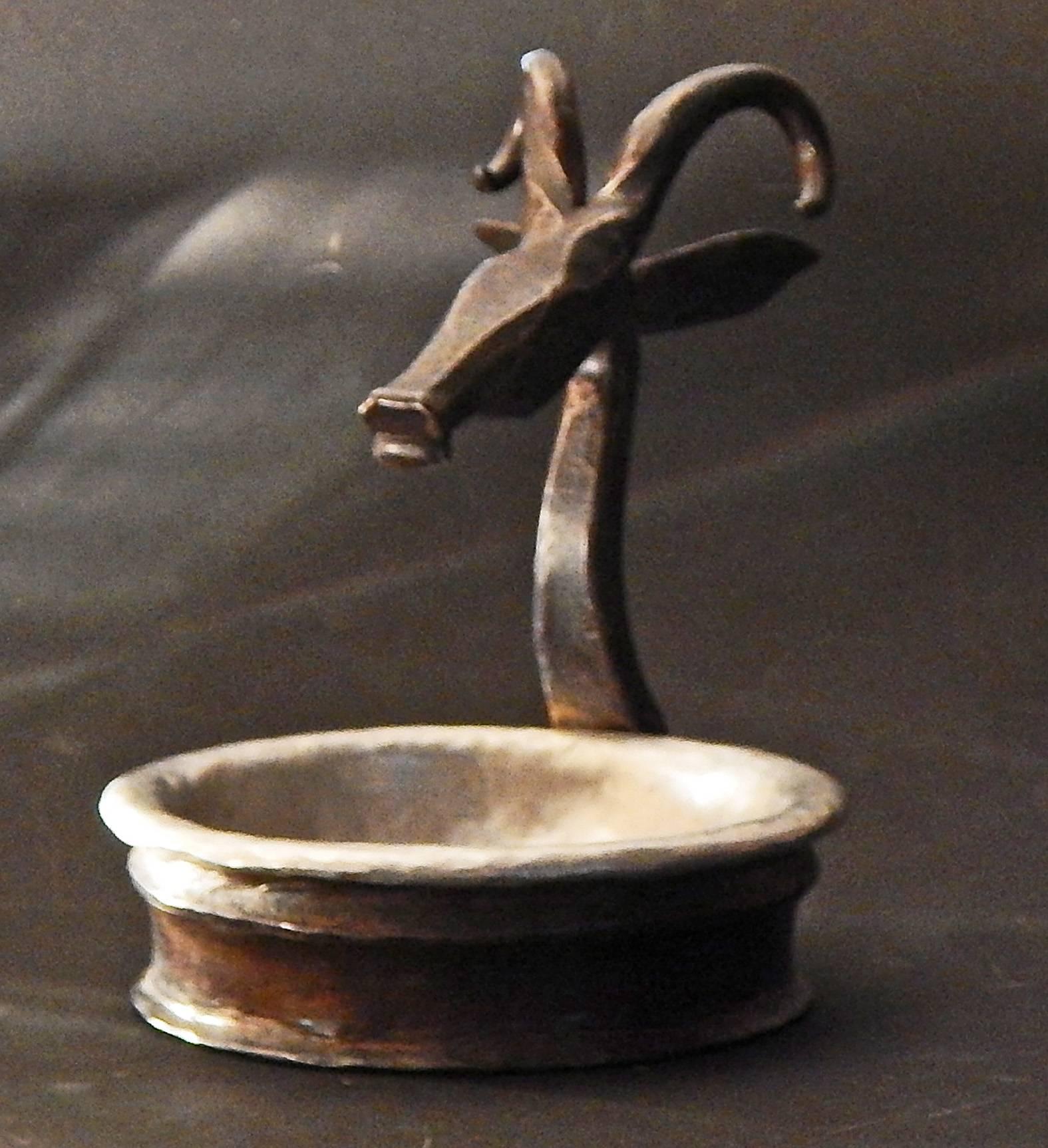 Superbly crafted in wrought iron and pewter, this lovely pin dish is surmounted by an antelope's head, stylized and simple, yet suffused with energy. Dating, no doubt, from the era when Oscar Bach and Samuel Yellin were at their height, in the 1920s