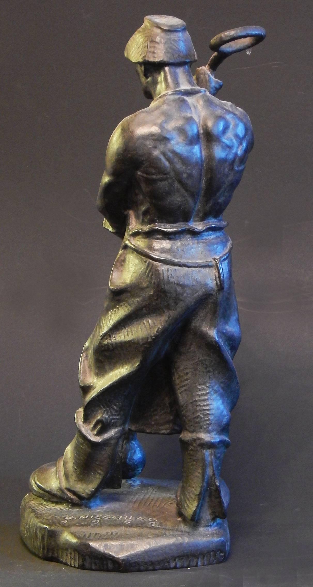 An extremely rare and powerful depiction of an Industrial worker with the tool of his trade at his feet, this steelworker, simply draped in a leather apron and heavy mittens, was sculpted by Karl Nieschlag. The artist studied under Josef Müllner at