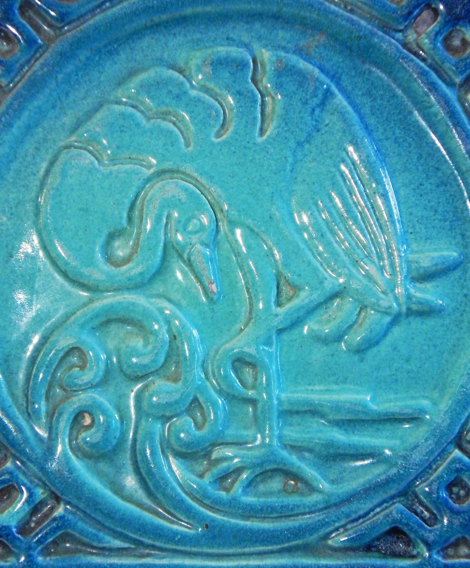 A fabulous mashup of Art Deco and 20th century chinoiserie, this rare and vivid tile, in shades of turquoise and cerulean, was made by Lulu Scott Backus in Rochester, New York. Backus had studied under the famous Charles Binns, who established