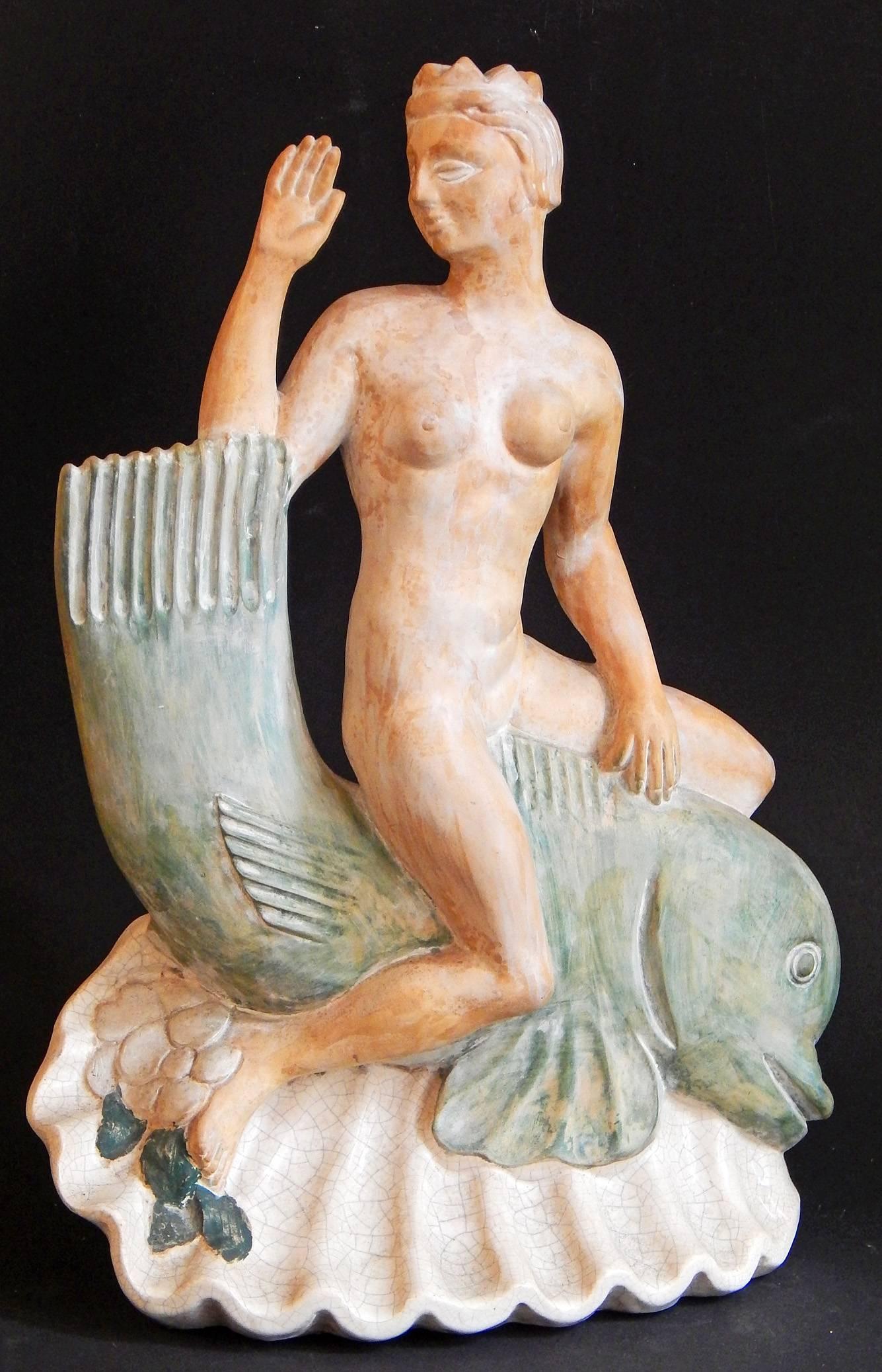 Large, bold and unique, this pair of Art Deco sculptures, originally designed to serve as lamp bases, depict Neptune and his wife Salacia riding the backs of whimsical, stylized dolphins resting on large shells. Neptune is shown with a trident on