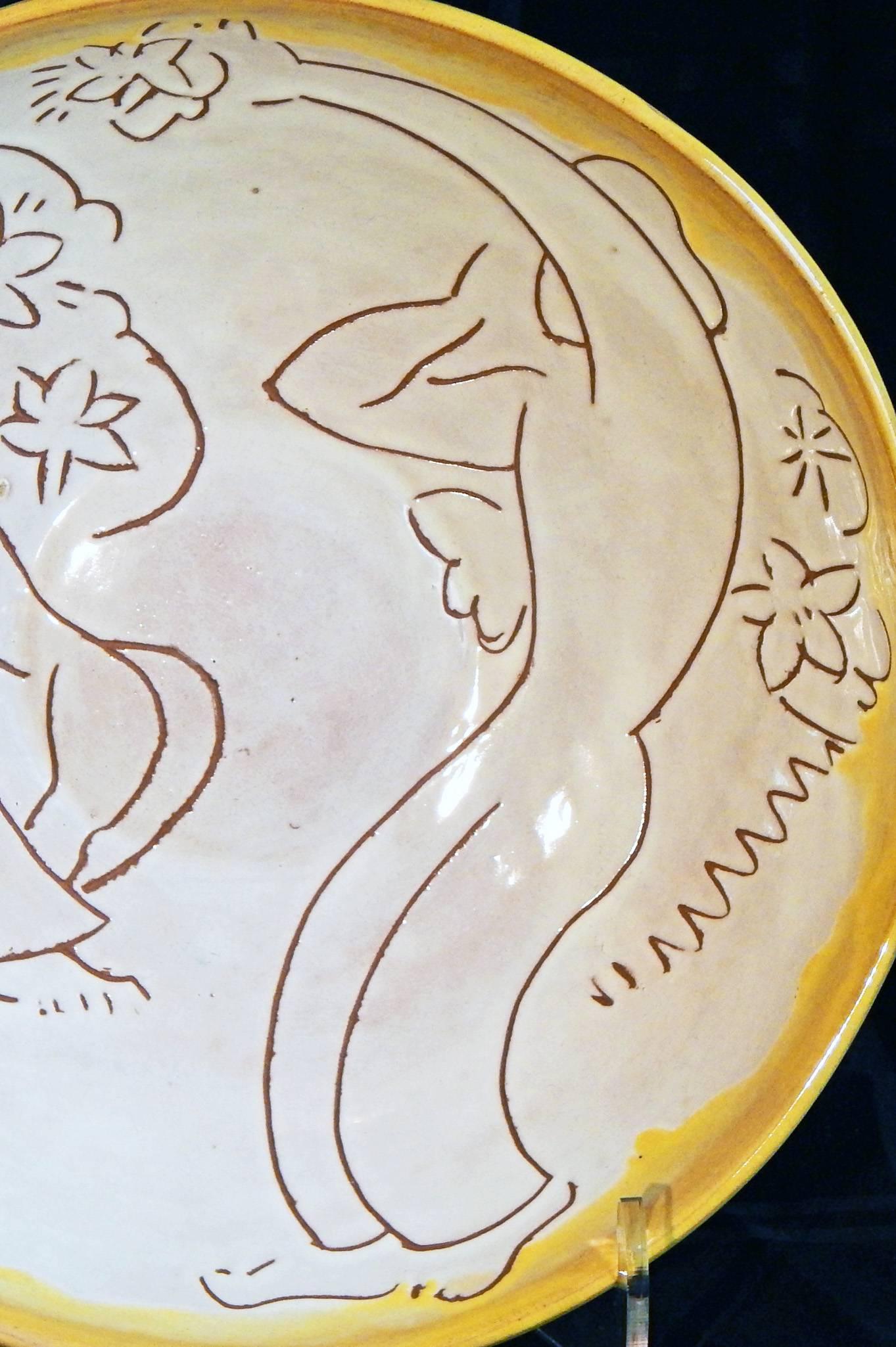 Clearly influenced by Matisse and other European modernists, this large and deep ceramic bowl with sgraffito decoration depicts a female nude and seated man amidst an array of floral motifs, ringed by a brilliant yellow aureole. The artist was Mary