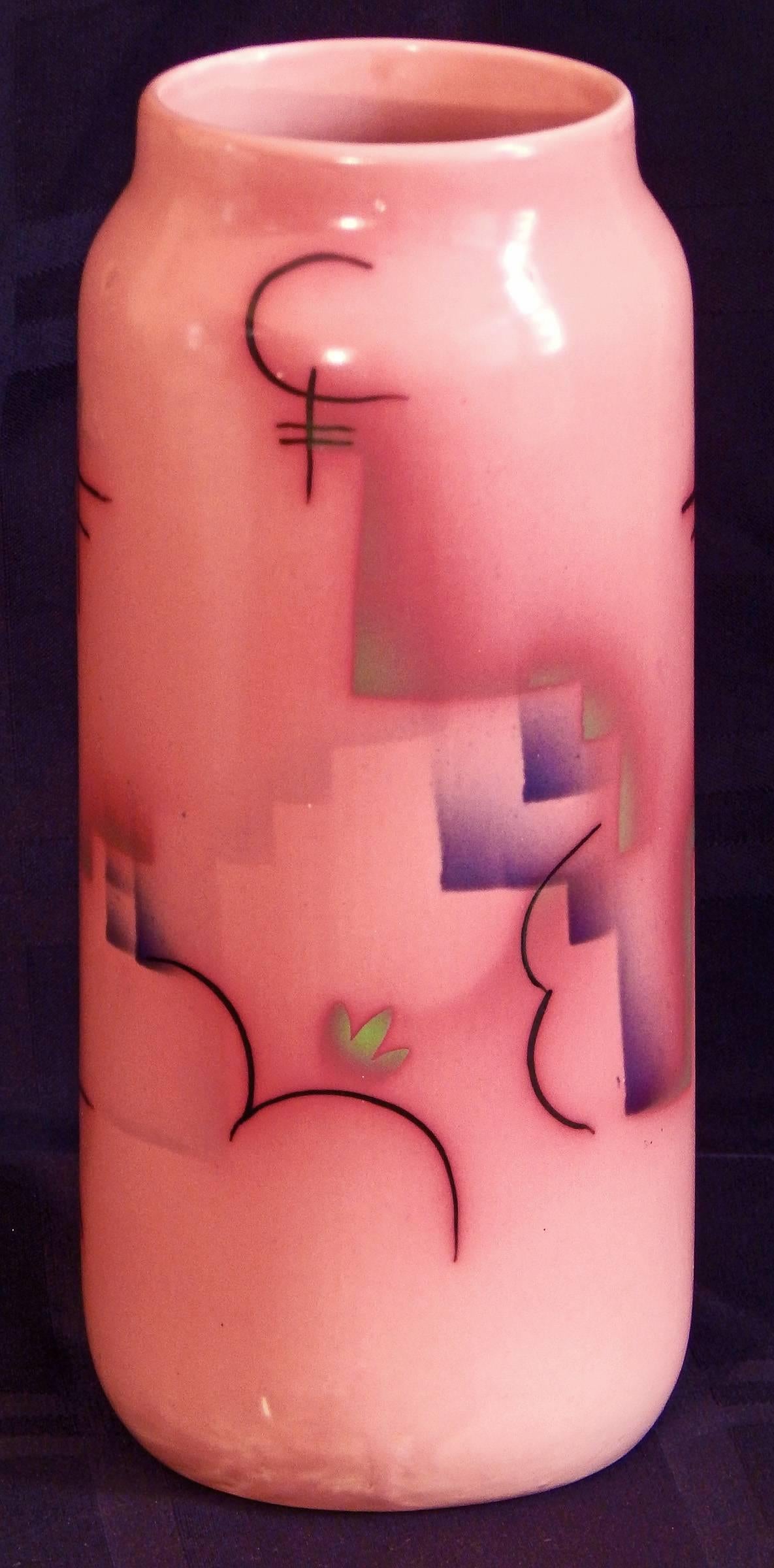 Clearly showing the influences of the Vienna Secession and the Wiener Werkstatte, at a time when Vienna led the Germanic world's interpretation of Art Nouveau and Art Deco, this cylindrical vase is glazed in a gorgeous ruddy pink and decorated with