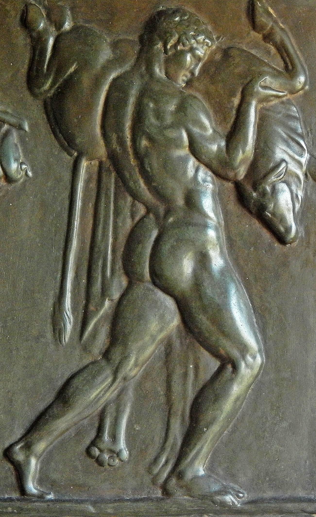 Sculptée avec audace et magnifiquement finie avec une glaçure vert mousse, cette sculpture en bas-relief représente un Hercule nu, portant peut-être le taureau crétois, suivi d'une figure féminine vêtue avec un sanglier et un lièvre. Clairement
