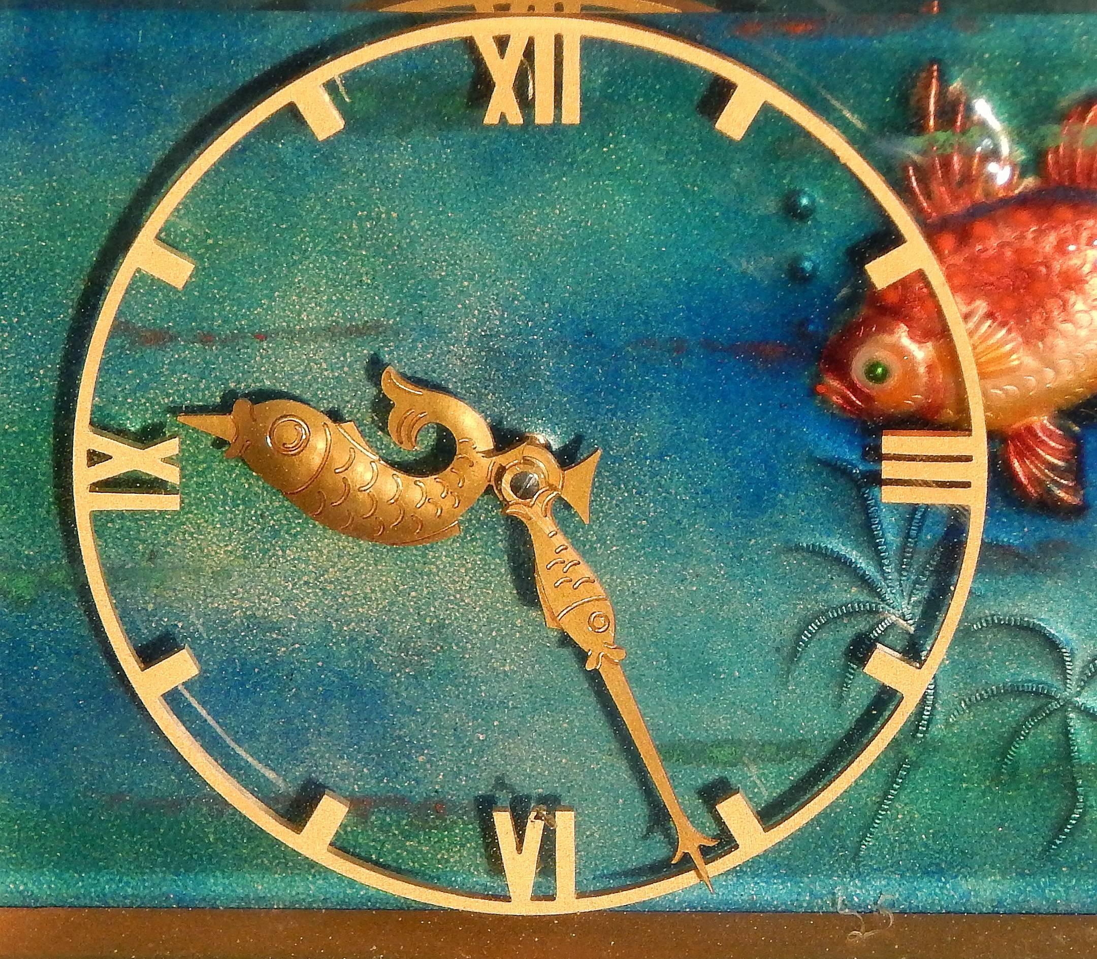 An especially fine and rare Art Deco clock, this aquatic-themed desktop piece was made by Arthur Imhof in Switzerland, probably not long after he begin to make clocks in 1939. The brilliantly-hued enameled fish on the face of the clock, together