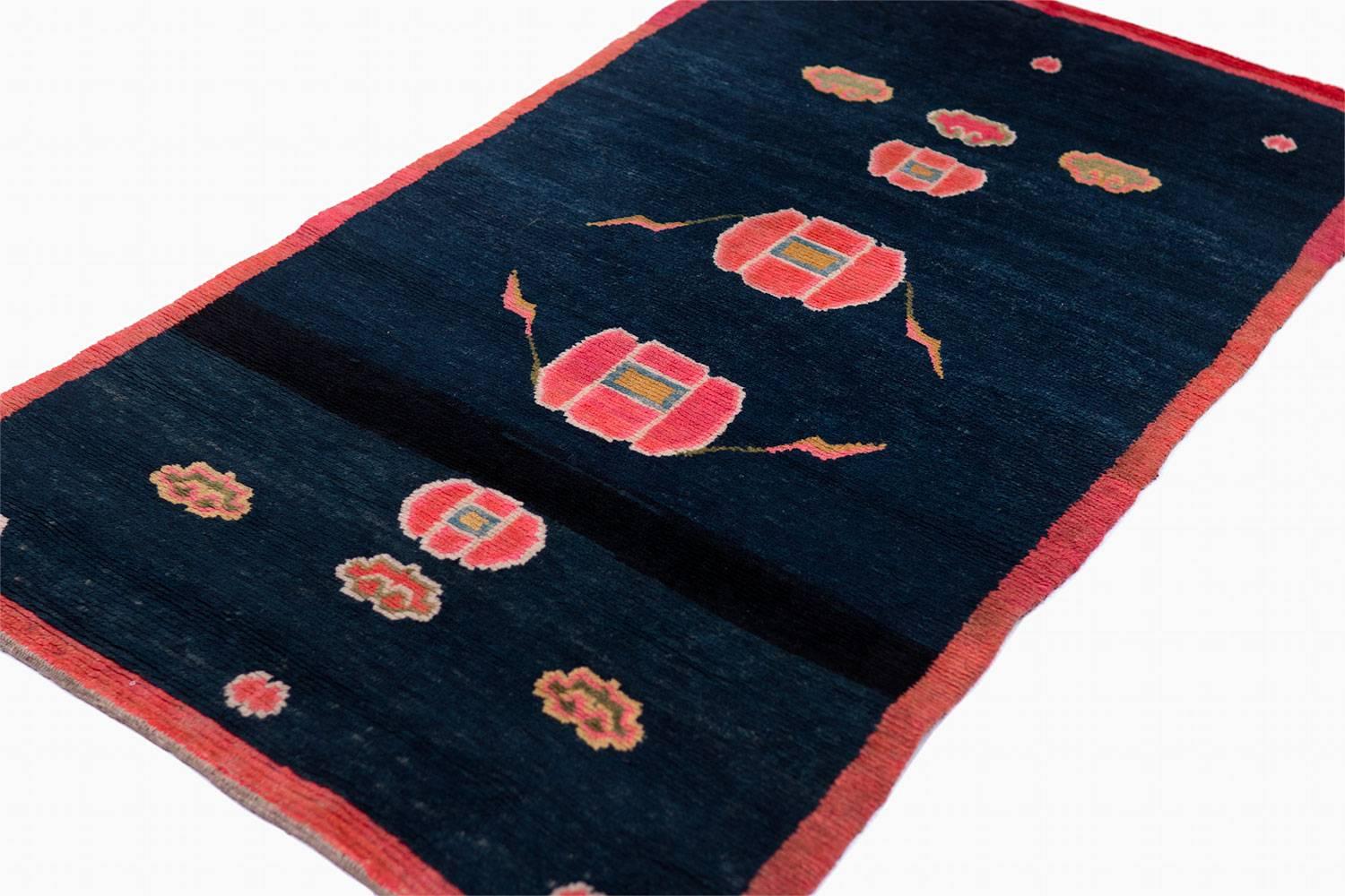 Silky lamb's wool and great indigo blue color characterize this unusually sparse and modern looking antique rug. The clouds and floral elements are unusual in their arrangement. The materials used in this small handwoven rug are superb.