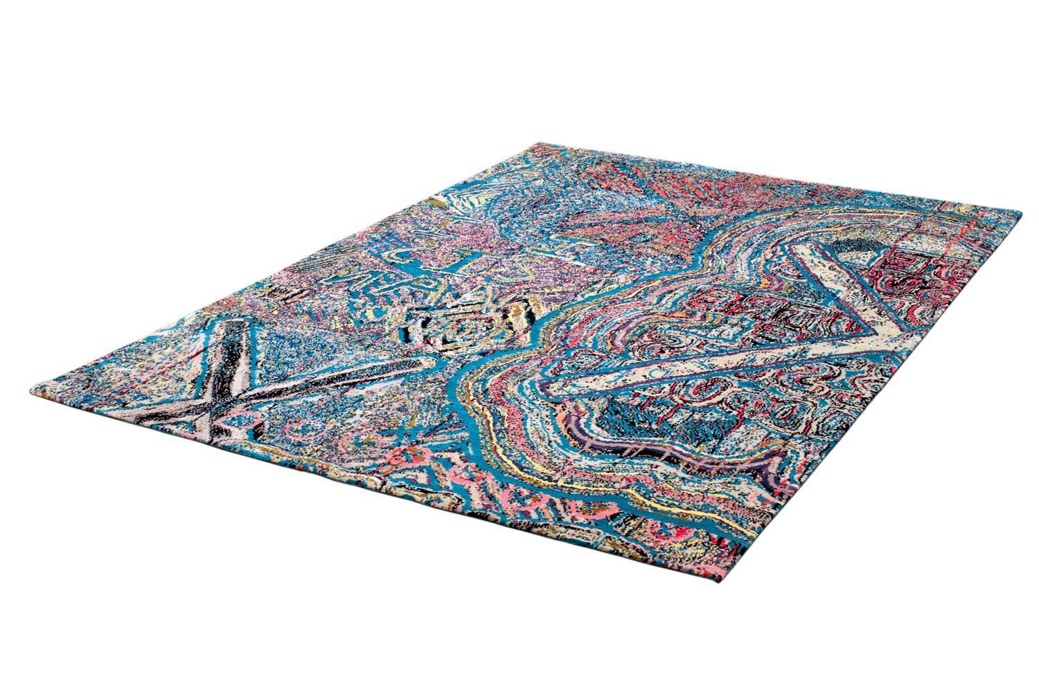 A highly detailed and complex design handwoven in Nepal using traditional Tibetan knotting techniques. The energetic colorful design is similar to that of an impressionist painting. The dominant hue is a popsicle blue but bursts of pink and yellow