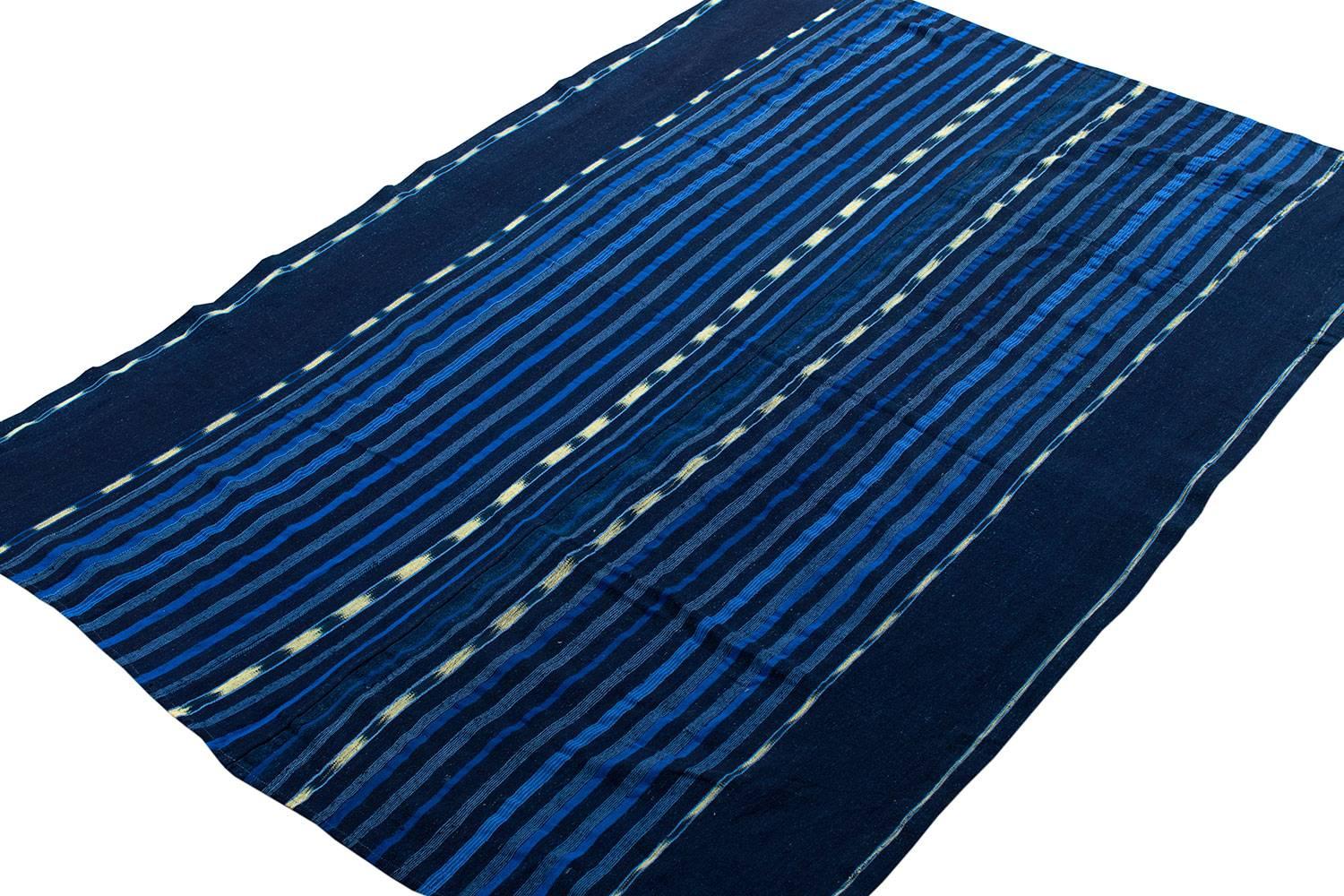 This vintage strip weave hand-spun cotton indigo cloth was woven from local hand spun cotton, giving a thick, soft texture. 

Indigo was the foundation of numerous textile traditions throughout West Africa. For centuries before the introduction of