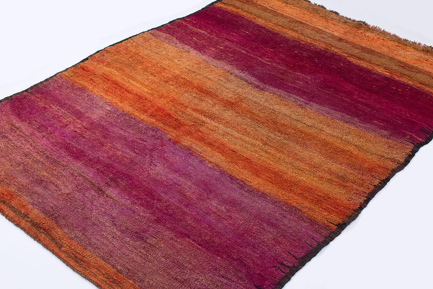 This Moroccan rug has fantastic abrash throughout the field. This piece comes from the Eastern ends of the Haouz plains and shows amazing color variation. This is certainly a piece that stands out and reminds us of a sunset!