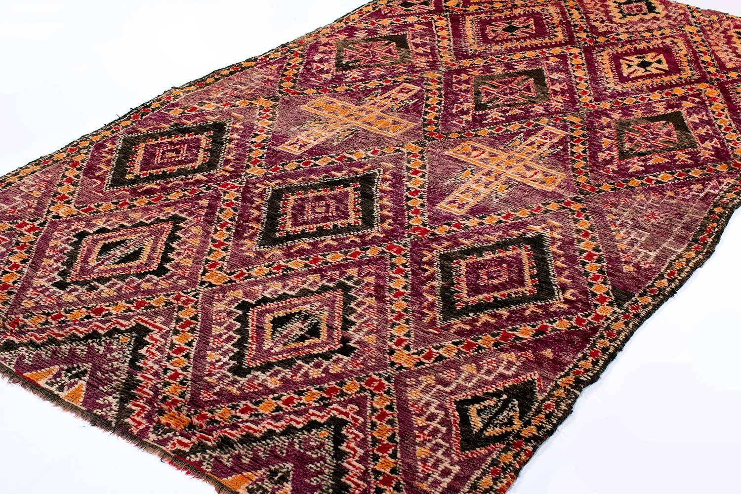 Vintage Moroccan Berber rug with beautiful motives and geometric elements and a great mauve/magenta color with deep indigo details and orange accents. This carpet was woven 50-60 years ago using silky hand-spun wool, from the Rif Mountains. The rug