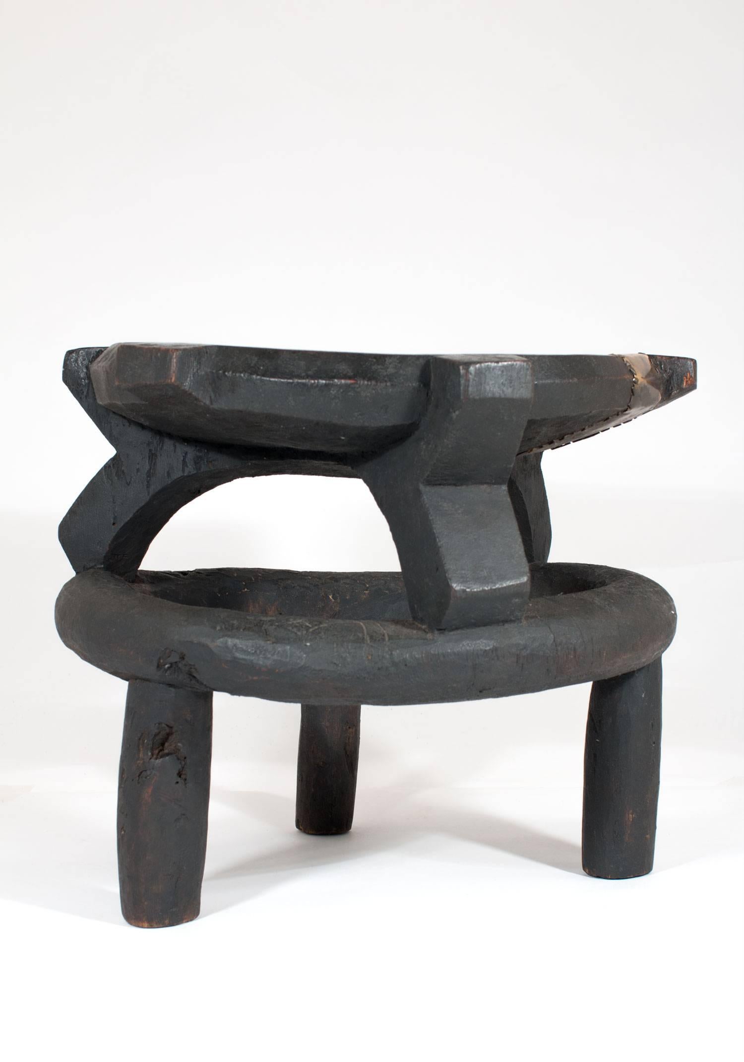 A hand-carved wooden stool from Tanzania with a native repair made from hand-hammered brass. This piece is very cool with a tribal vibe.
