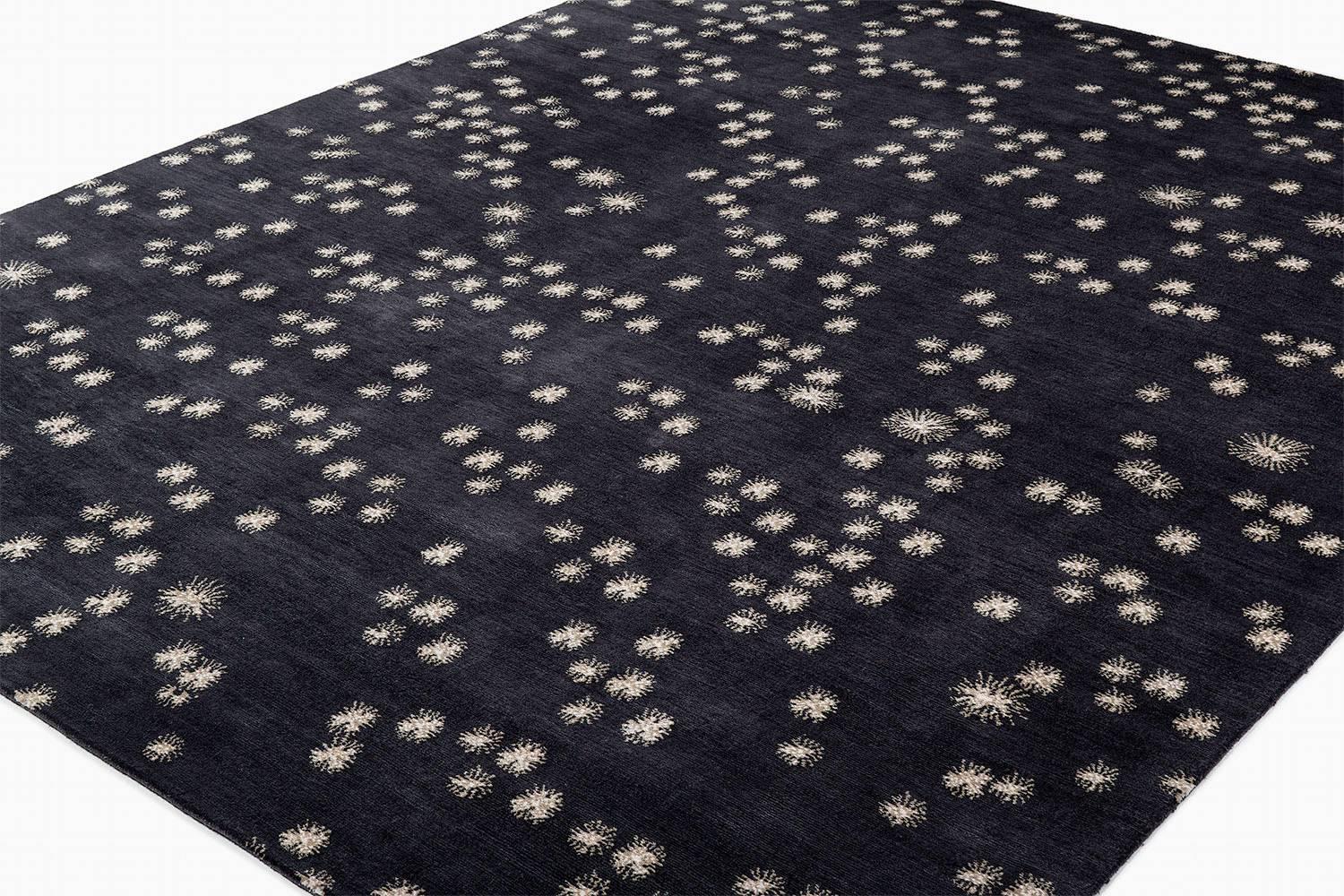 

A dark soft and inviting carpet, Japanese Asterisk features ethereal puffs of beige across an eggplant-toned background. The silk and wool blend woven in 100 knots is luxurious and simple in design. Original design by Joseph Carini Carpets.