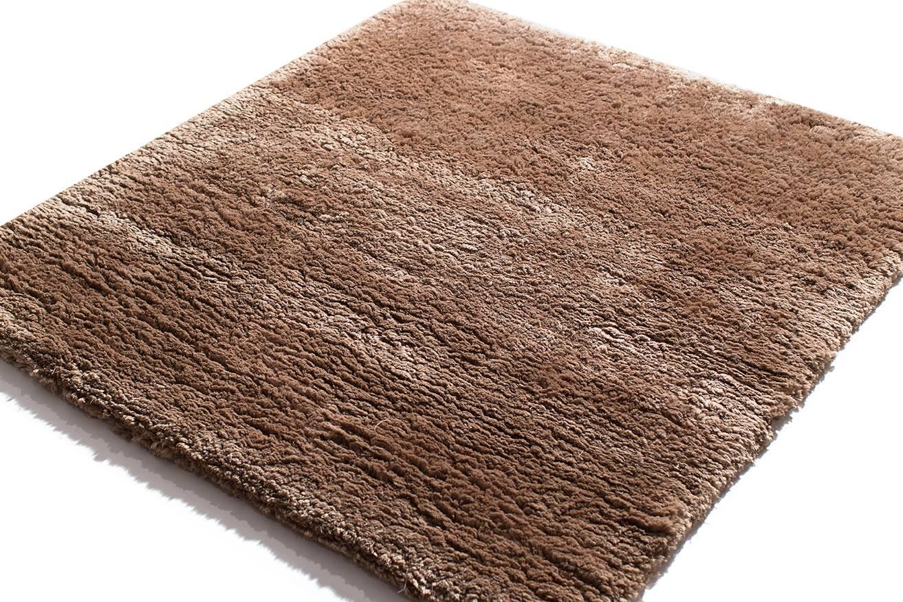 This 100 knot, 15mm silk shag is extremely plush and soft pile. Hand-knotted in Nepal, using the finest grade Chinese silk. Measures: 3 ft by 3 ft. The sheen on the silk makes the coffee color shimmer with bronze accents. Original design by Joseph