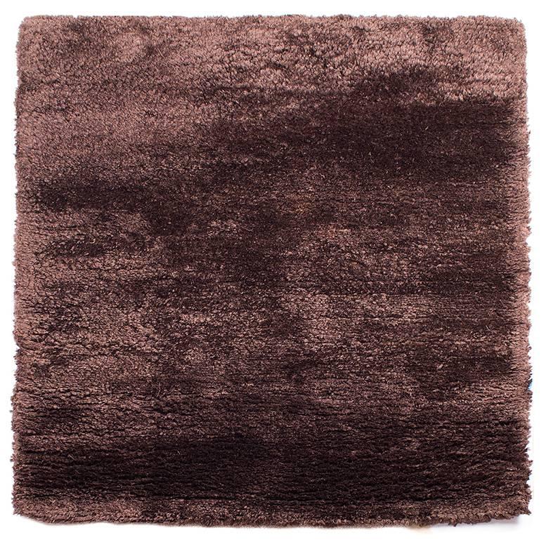 This 100 knot - 15mm silk shag is extremely plush and soft pile. Hand-knotted in Nepal using the finest grade Chinese silk. Measures 3 ft by 3 ft. The sheen on the silk makes the chocolate brown color shimmer with bronze accents. Original design by