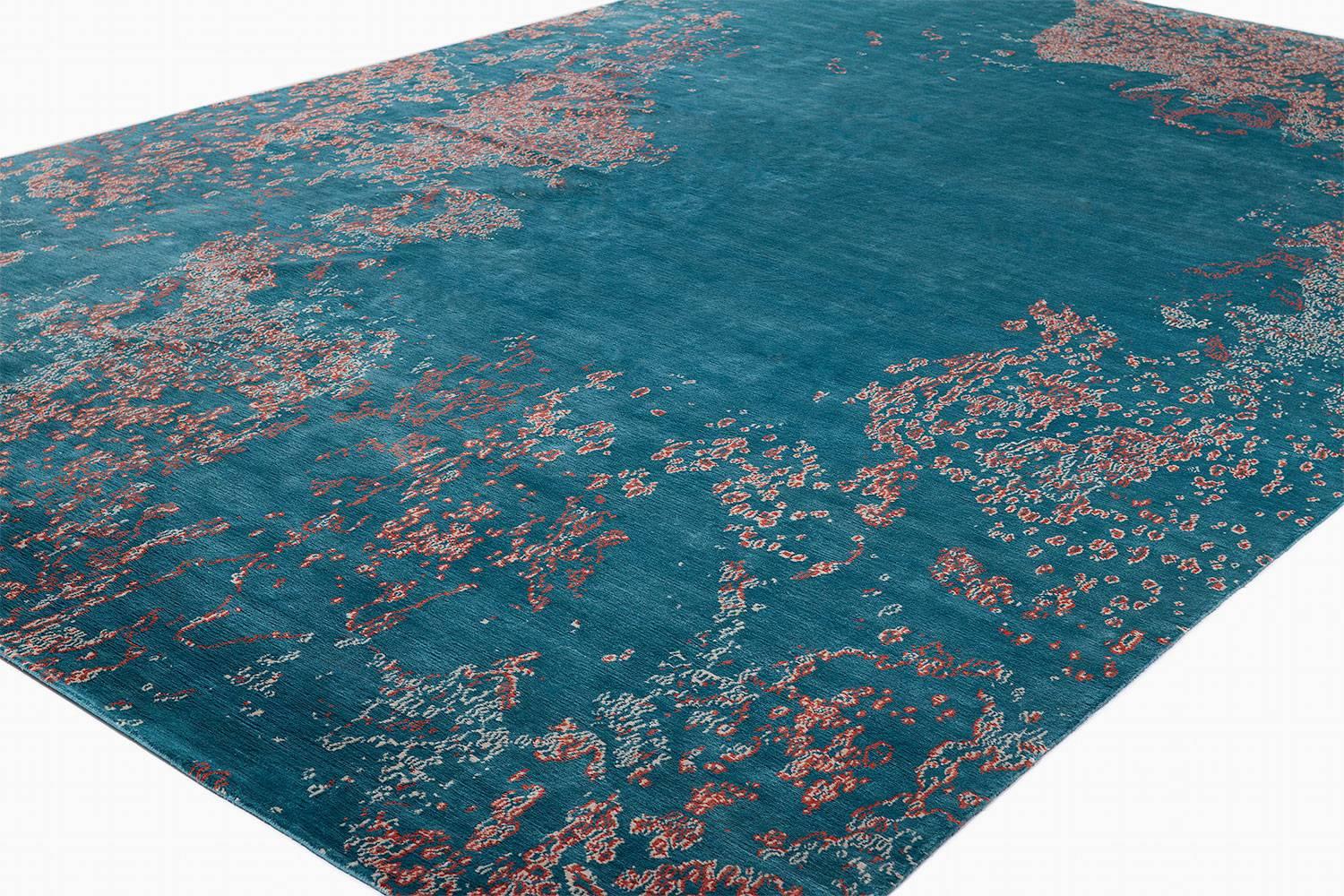 This couture carpet design by Joseph Carini was loosely inspired by his love of coral reefs. We colored this carpet in a sumptuous aqua blue with coral red and off-white accents, giving a sense infinite space. Woven with the highest quality silk