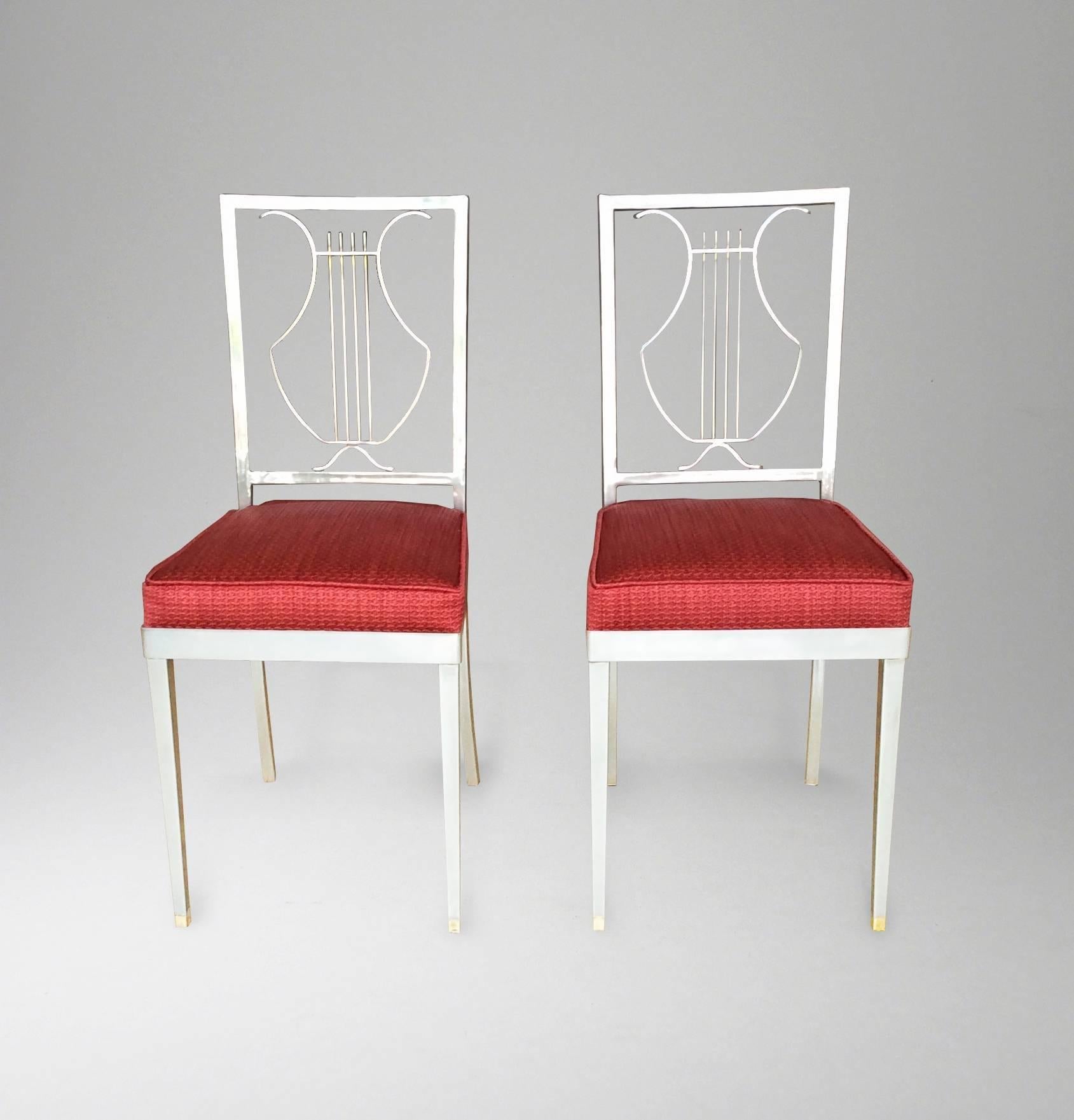 French, 1970s
Each in brushed metal finish, with stylized 'lyre' backrest
Seats re-upholstered in coral rust colored woven fabric.