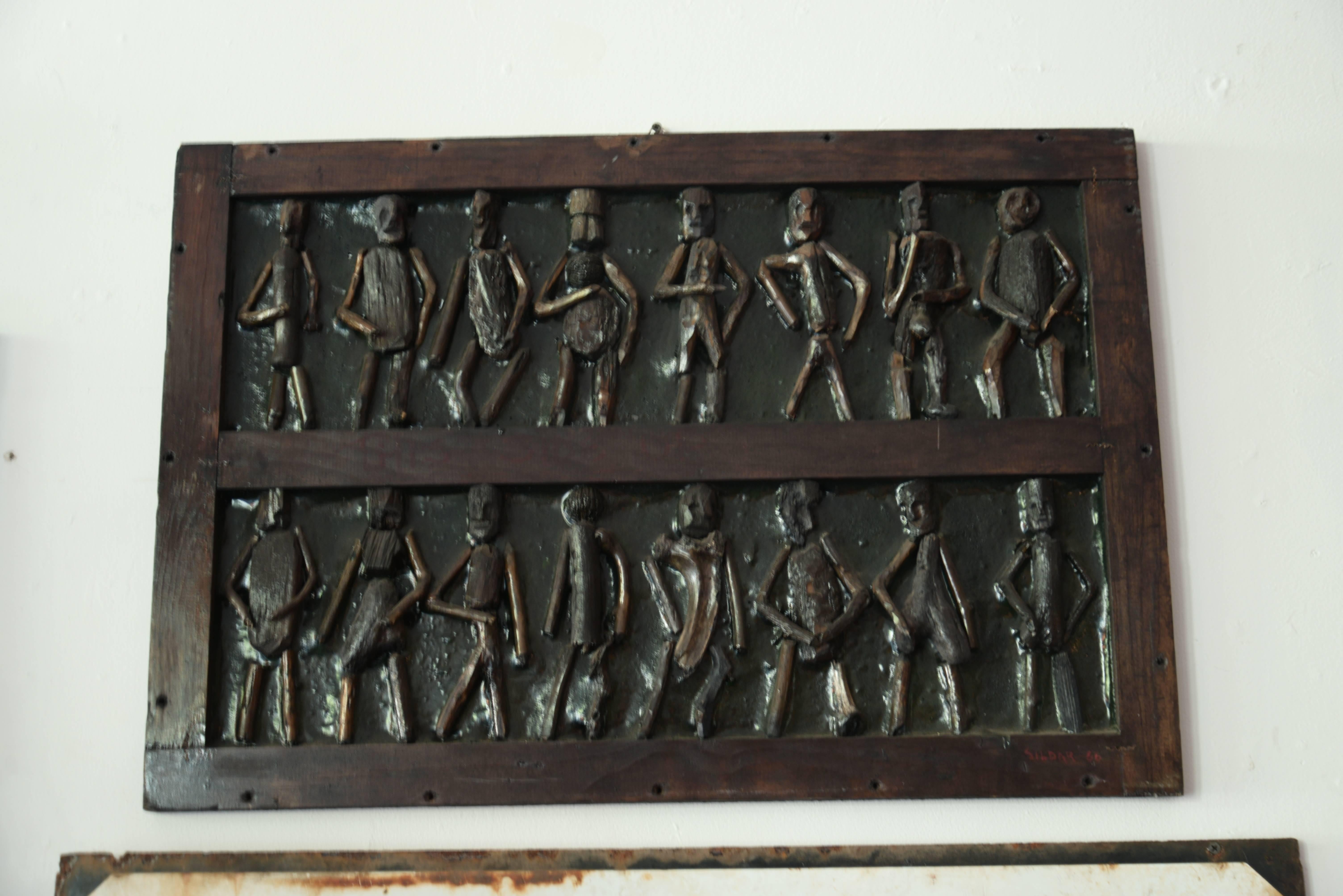 Hand-carved wooden figures inset into a shipping crate.
