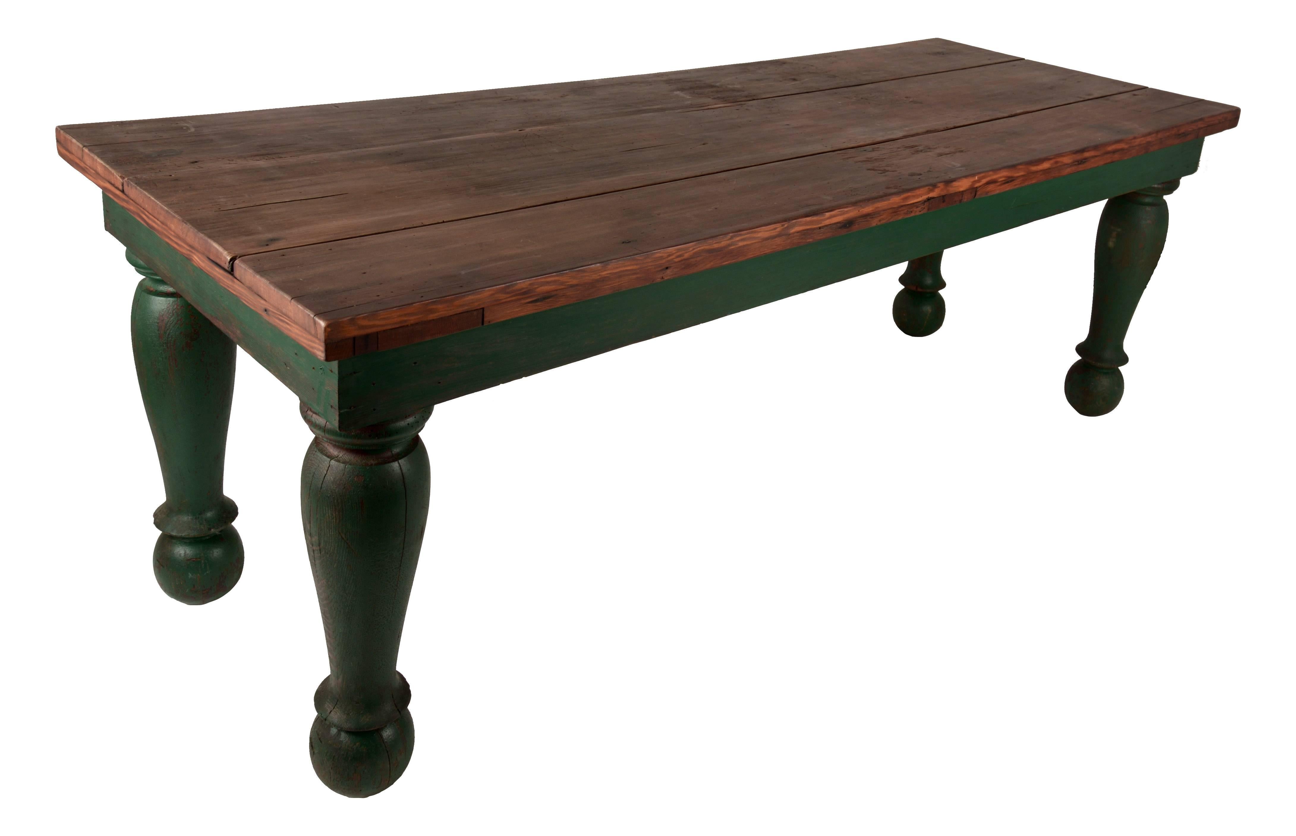 Late 19 century low table with wood top and massive turned green painted wooden legs.