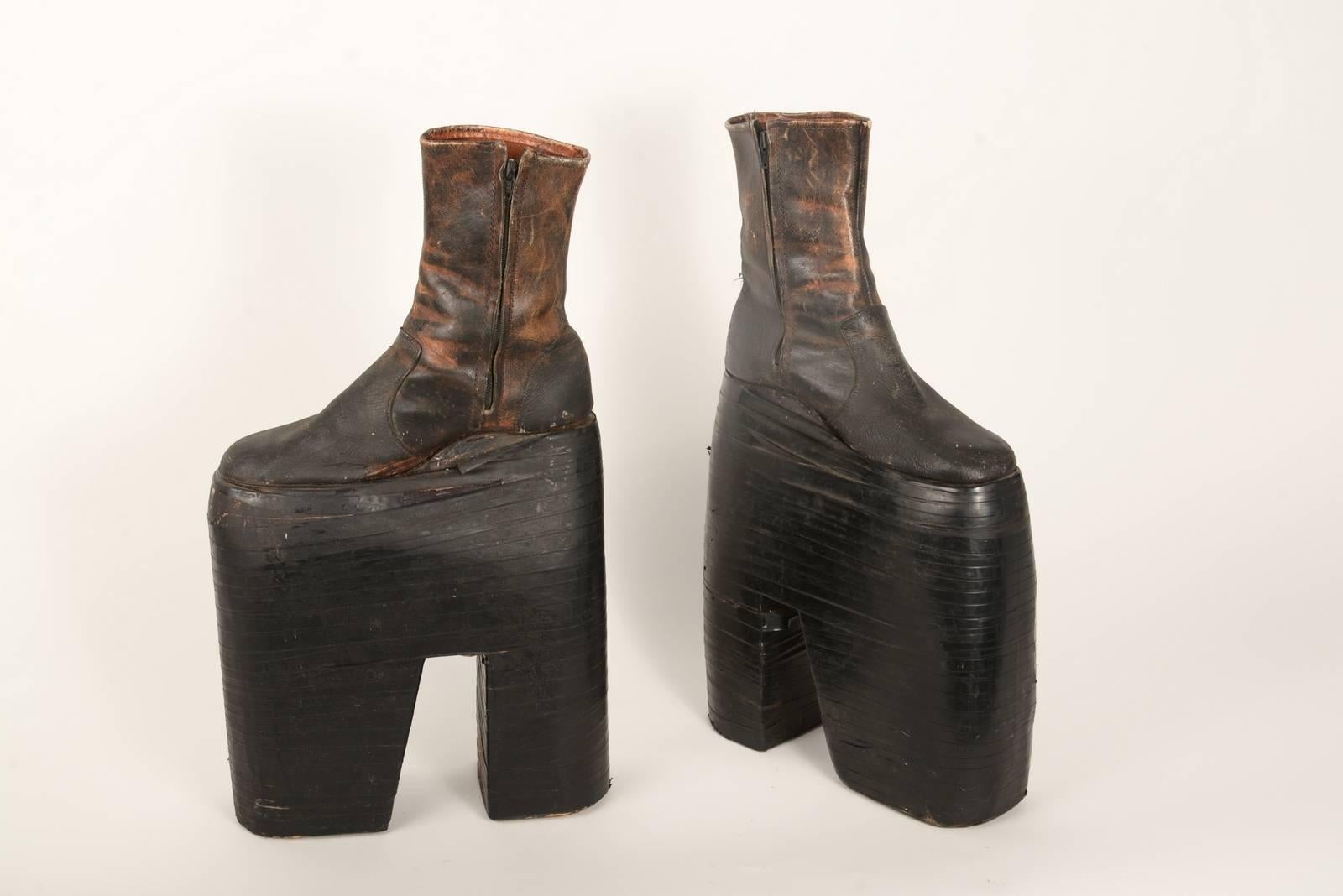 Modified 1960s leather zip up ankle boots. The bases are carved out of wood and wrapped in electrical tape.