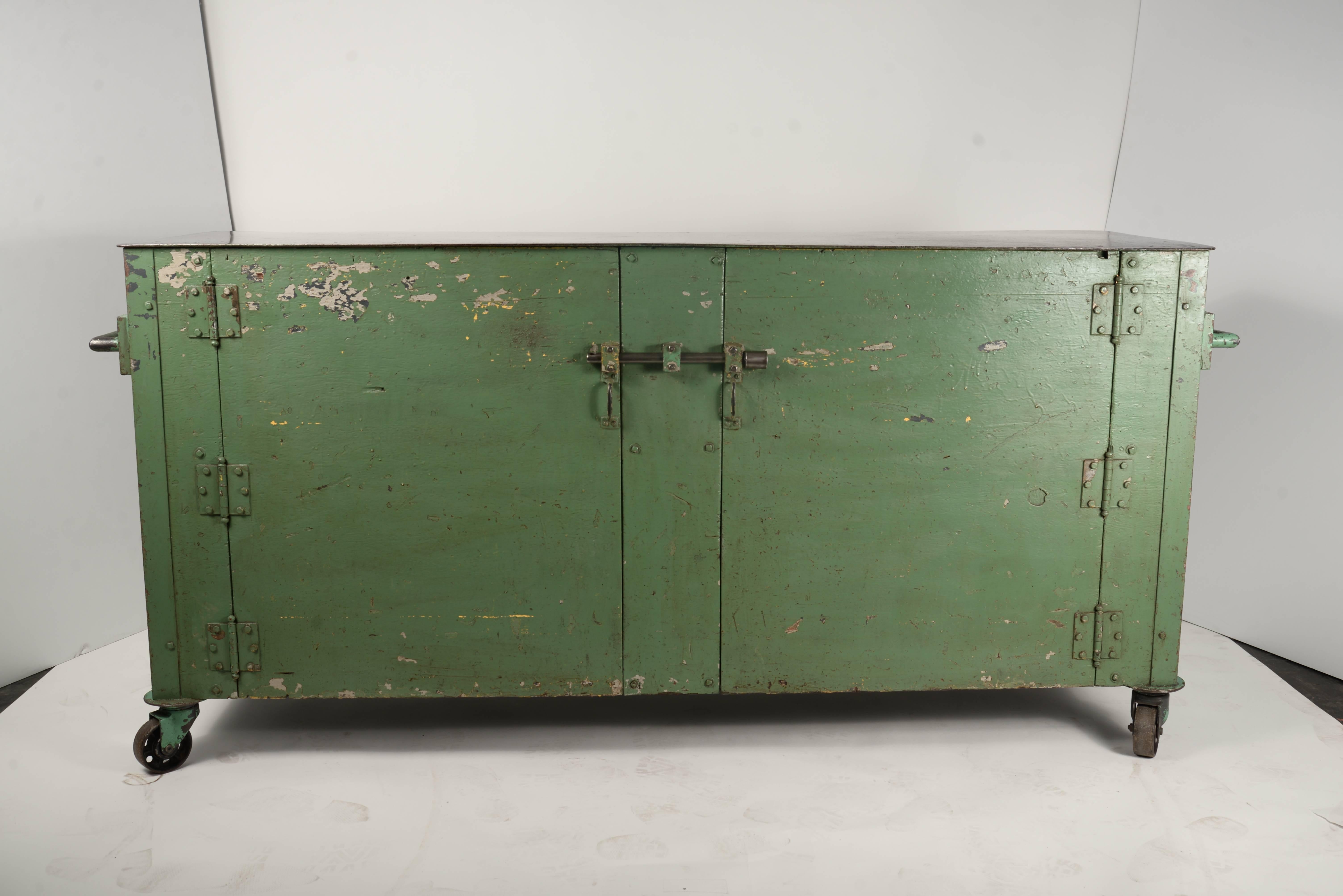 Two-door steel top wooden framed workshop cabinet on casters. The unit is electrified with outlets on each side and interior lighting.