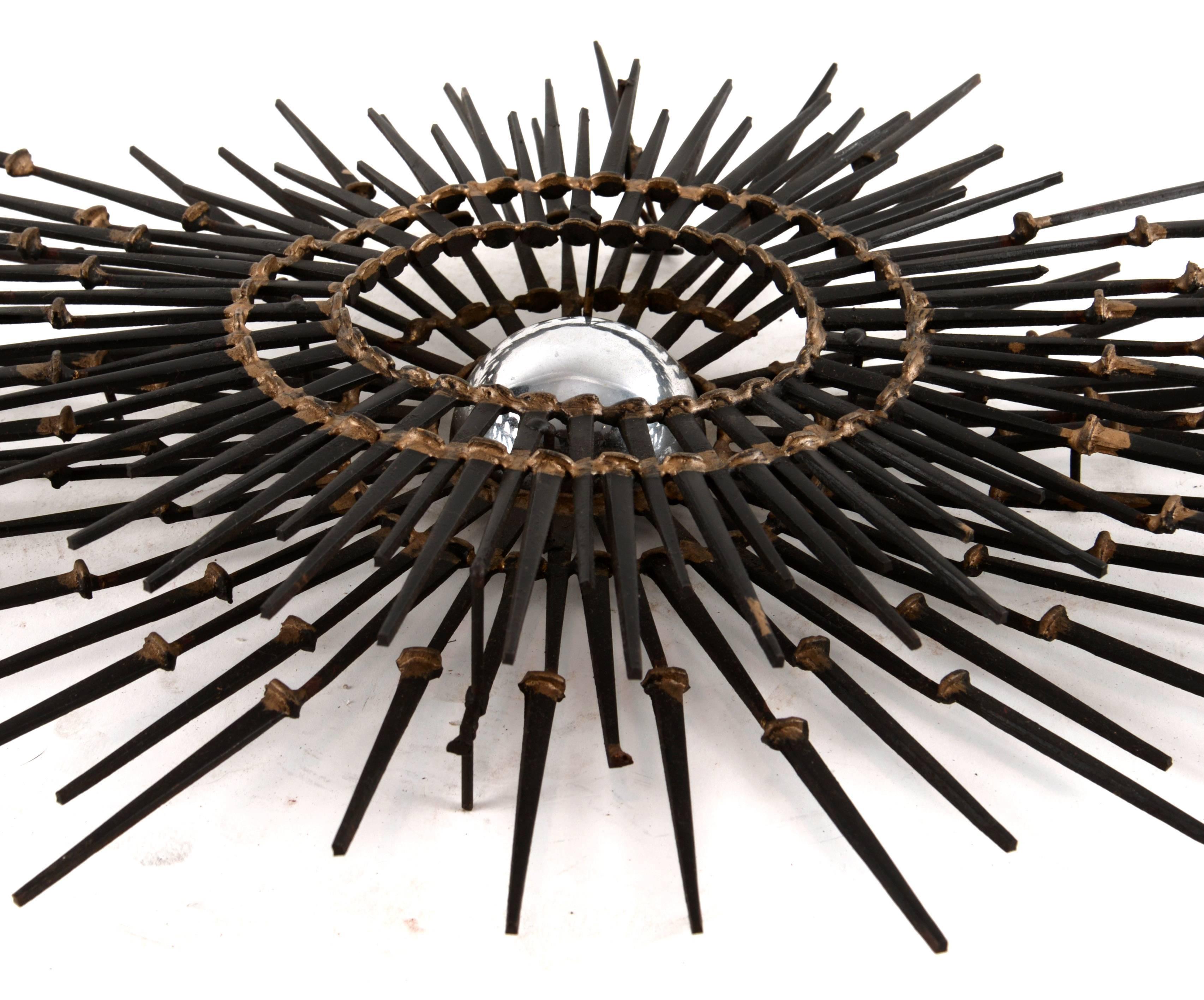 An elongated two-tier starburst created from black square nails with bronze welds. The interior half sphere is mirror glass.