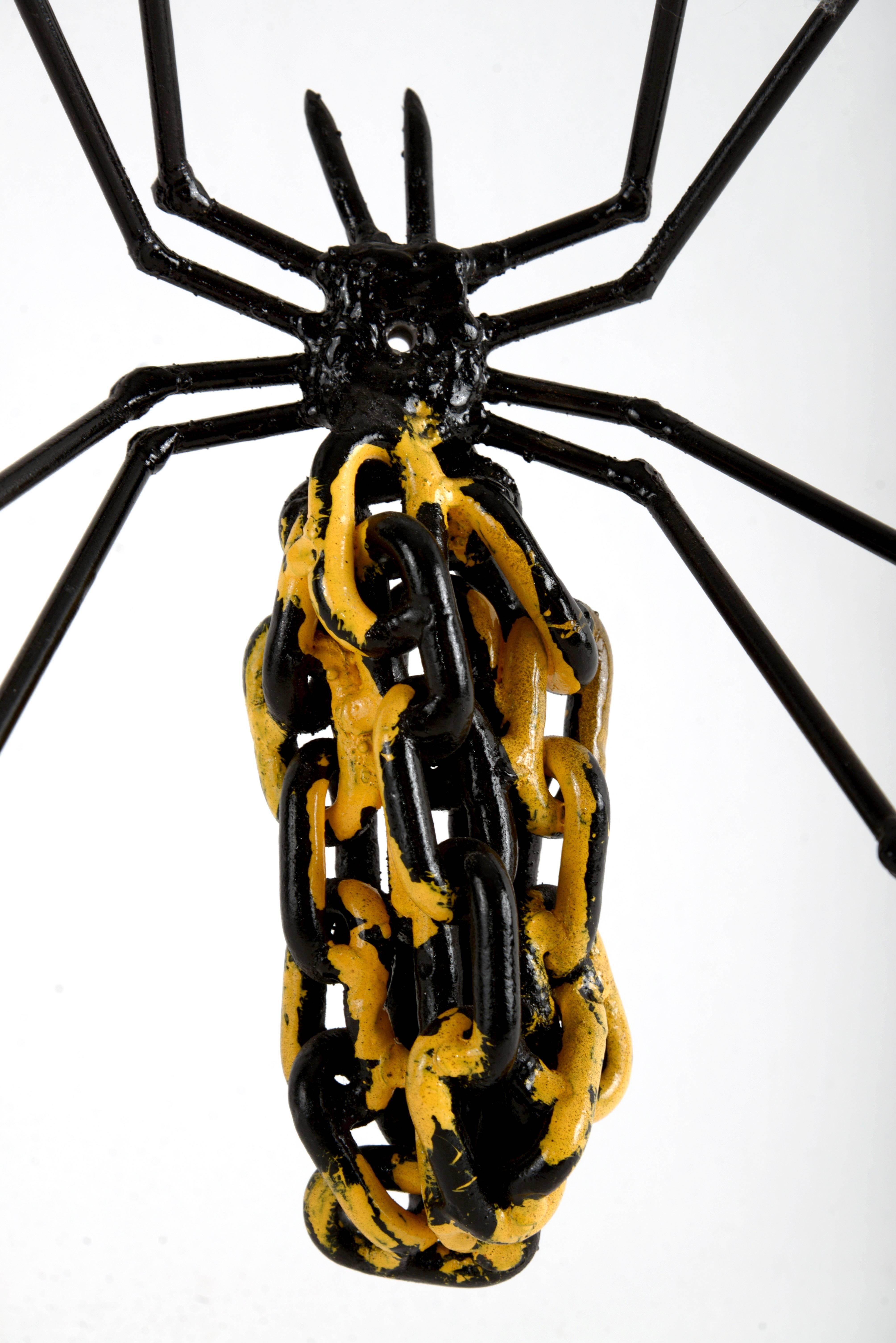 Oversized sculpted metal spider with yellow and black painted chain thorax.