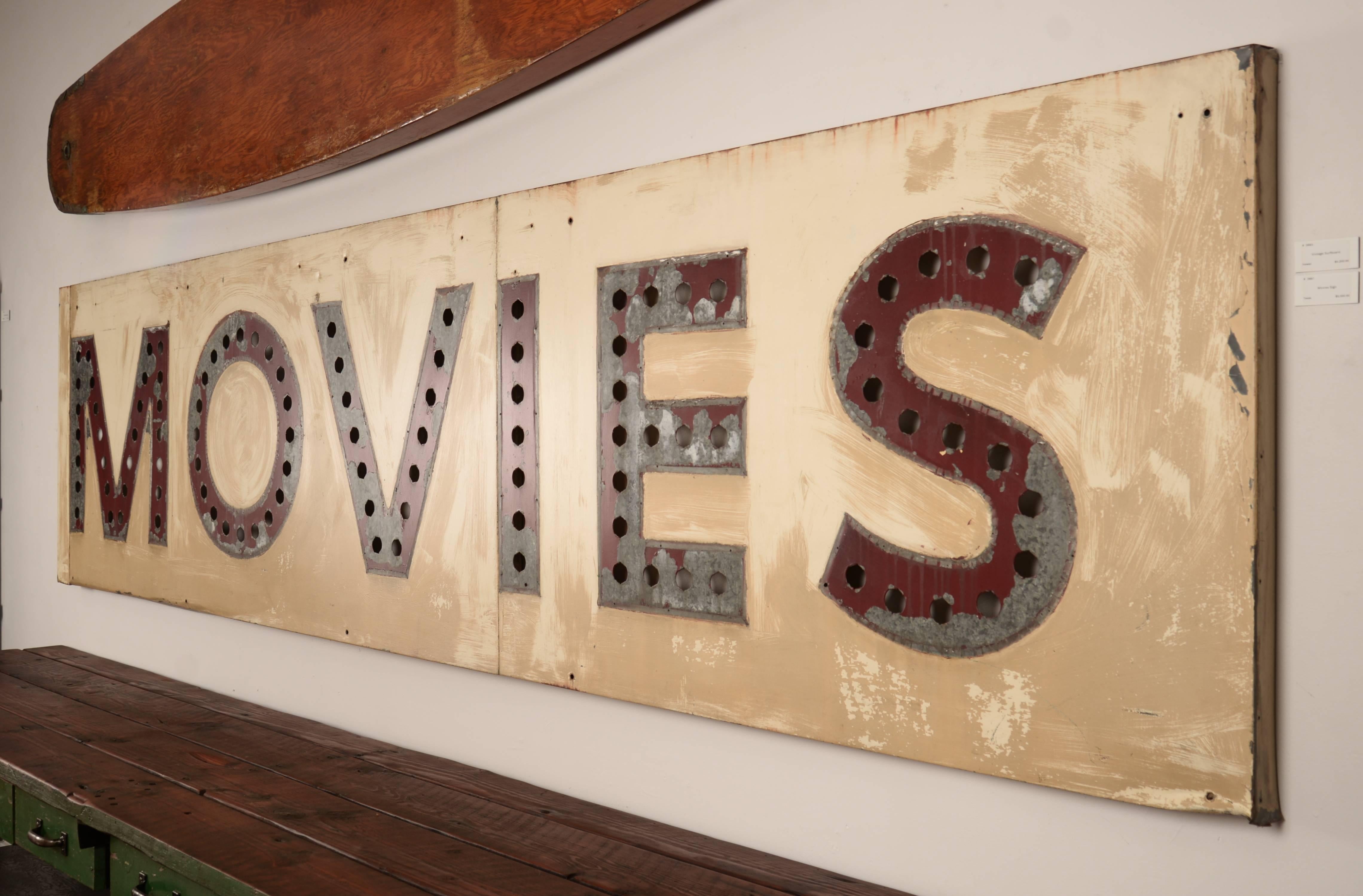 Massive painted steel movie theatre sign. The holes once held medium socket bulbs that probably flashed and chased. We've created a full length wooden wall-mounted cleat for easy and safe display.