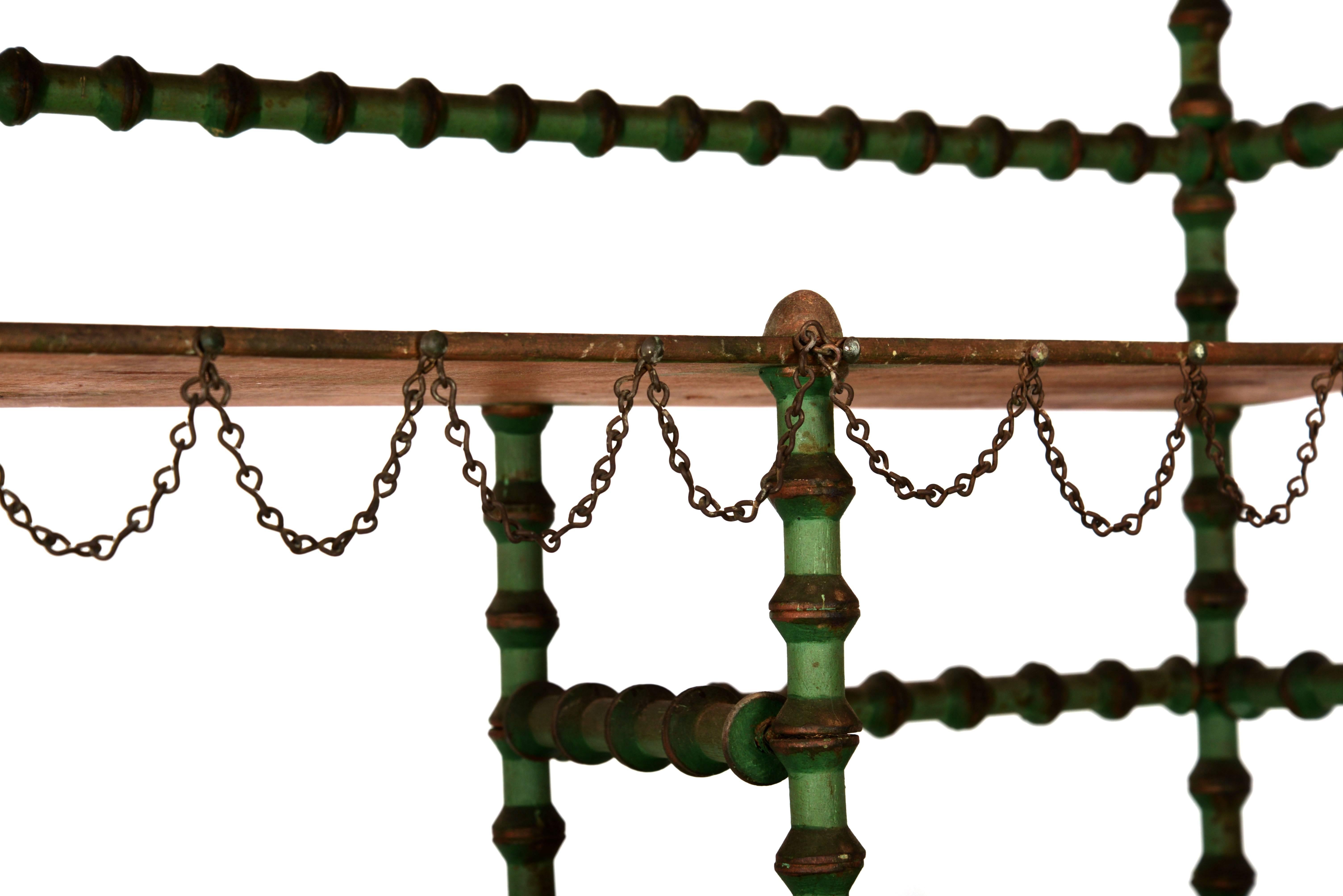 Unique green painted wooden spool shelving unit with chain detailing.