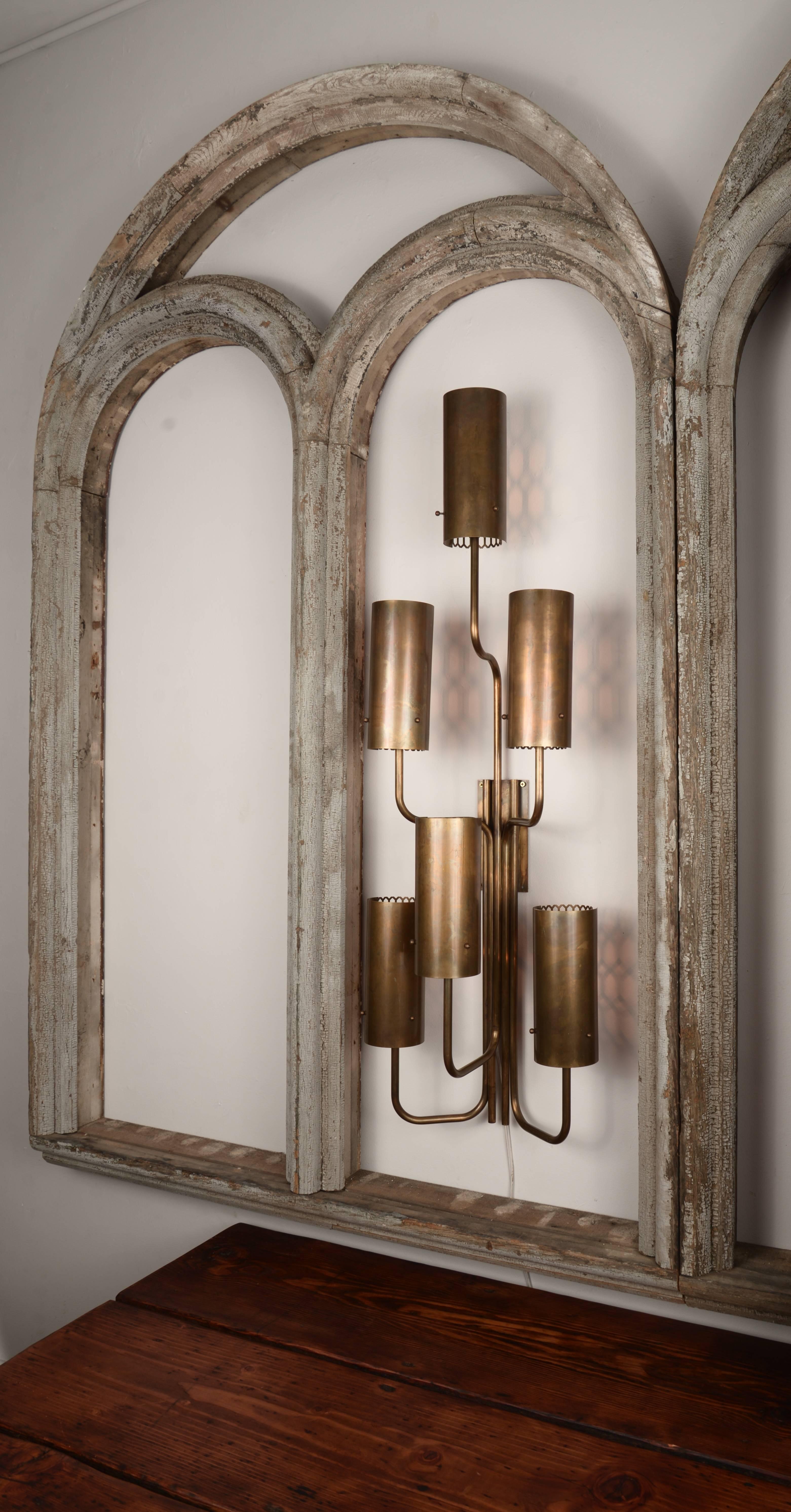 Pair of vintage brass five-light wall sconces harvested from the Seattle Opera House. They have a lovely mesh backing that casts a patterned shadow on the wall behind them. These have been attributed to Irene McGowan.