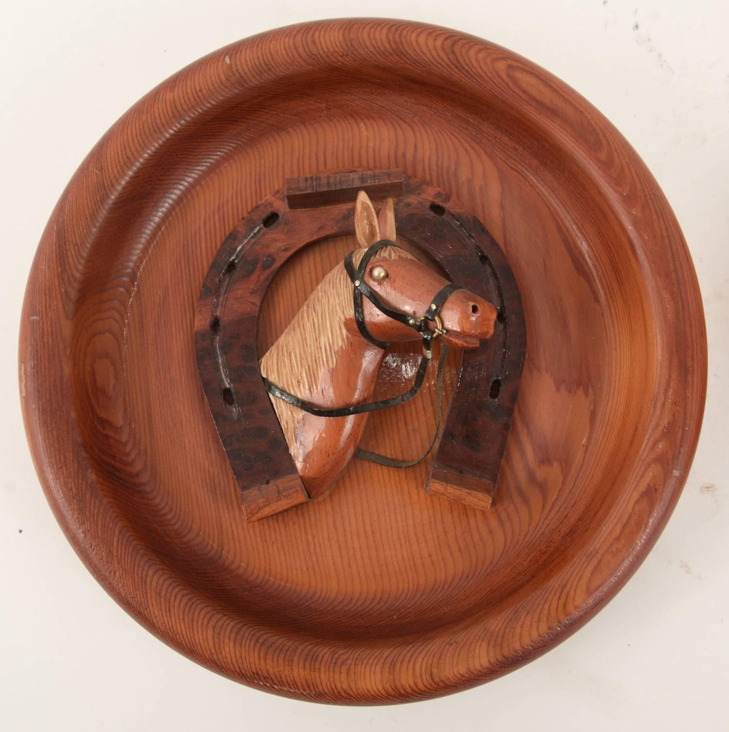 Pair of relief sculptures with an equestrian theme featuring two different horses surrounded by a wooden horse shoe. These are signed by the maker Lou Genereaux.