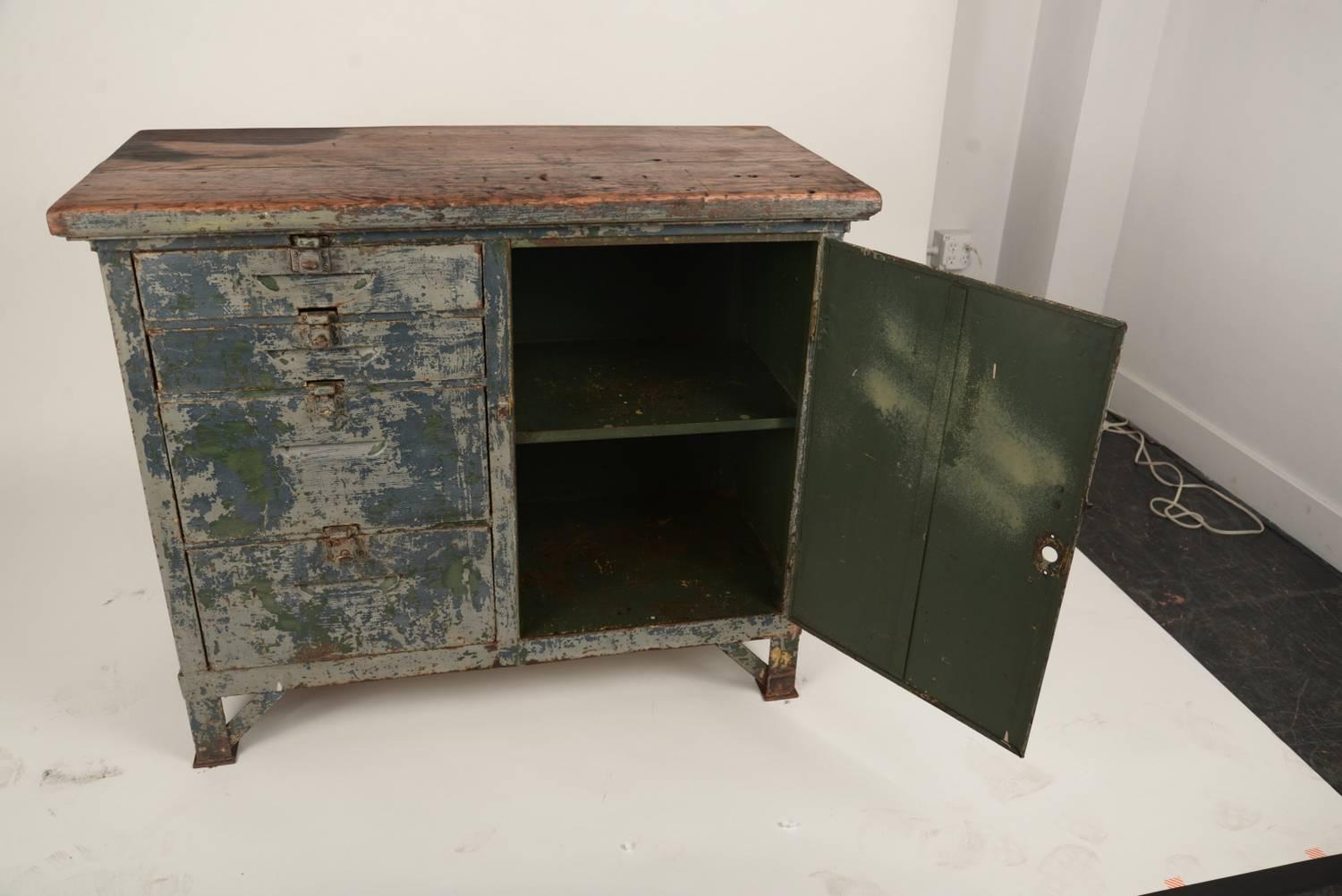 Sturdy stout and very clean this steel cabinet with an oak top as remnants of it's original blue greenish gray paint. The dark area on the top is evidence of a fire. The entire piece has been thoroughly cleaned and sealed and is ready to enjoy in