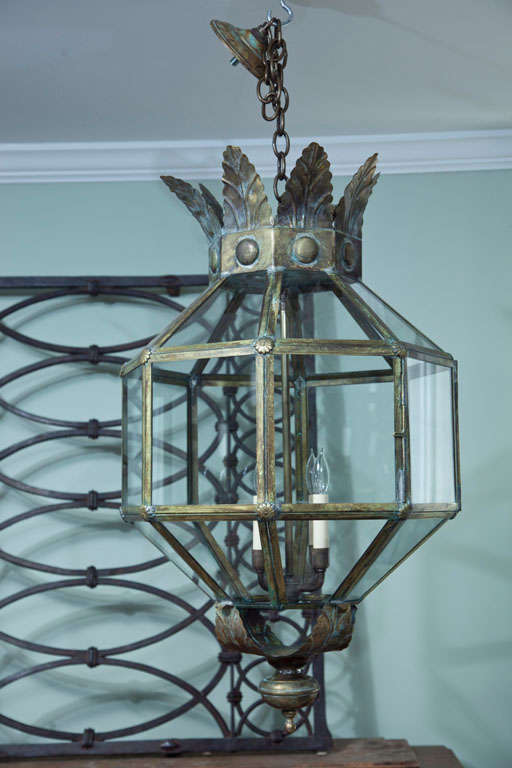 A lovely antiqued octagonal glass encased lanterns in hand-forged brass, newly electrified to US standards with four lights, available as a single, more can be made if multiples are needed
The interior chandelier is outfitted in our workshop and