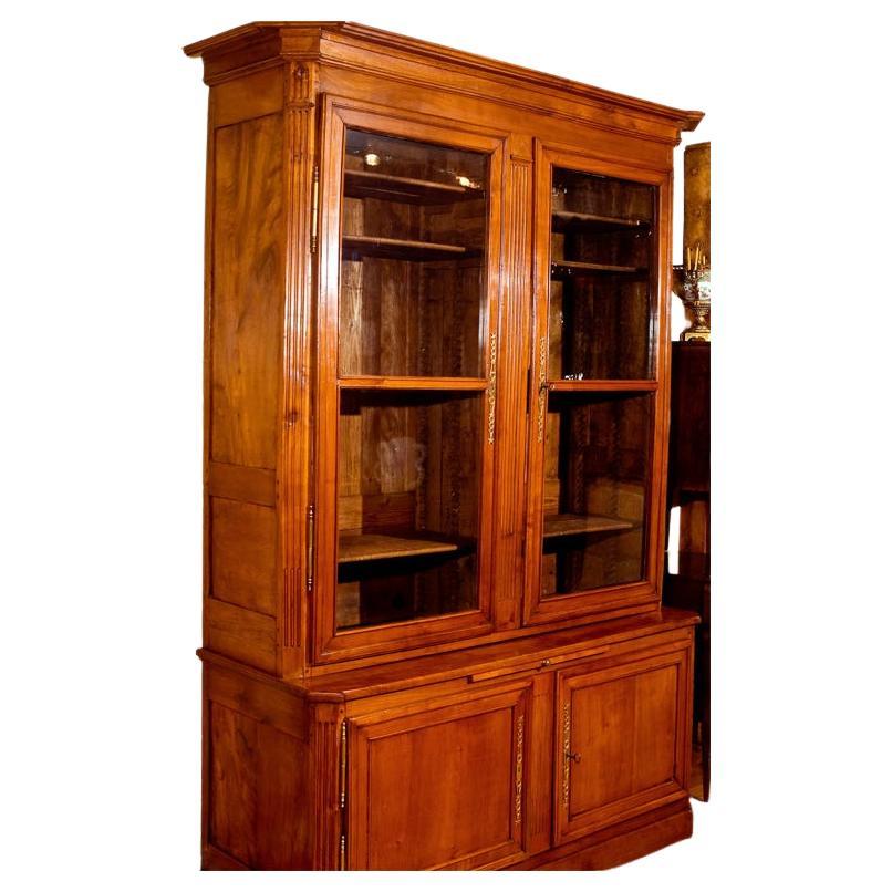 Fine early 19th century French Biblioteque in a blonde mahogany wood and comprised of four doors  with the upper case doors paneled in old bubble glass and a pull-out table in its center, brass hardware original
Dating 1840ca
Origin: Bordeaux Region