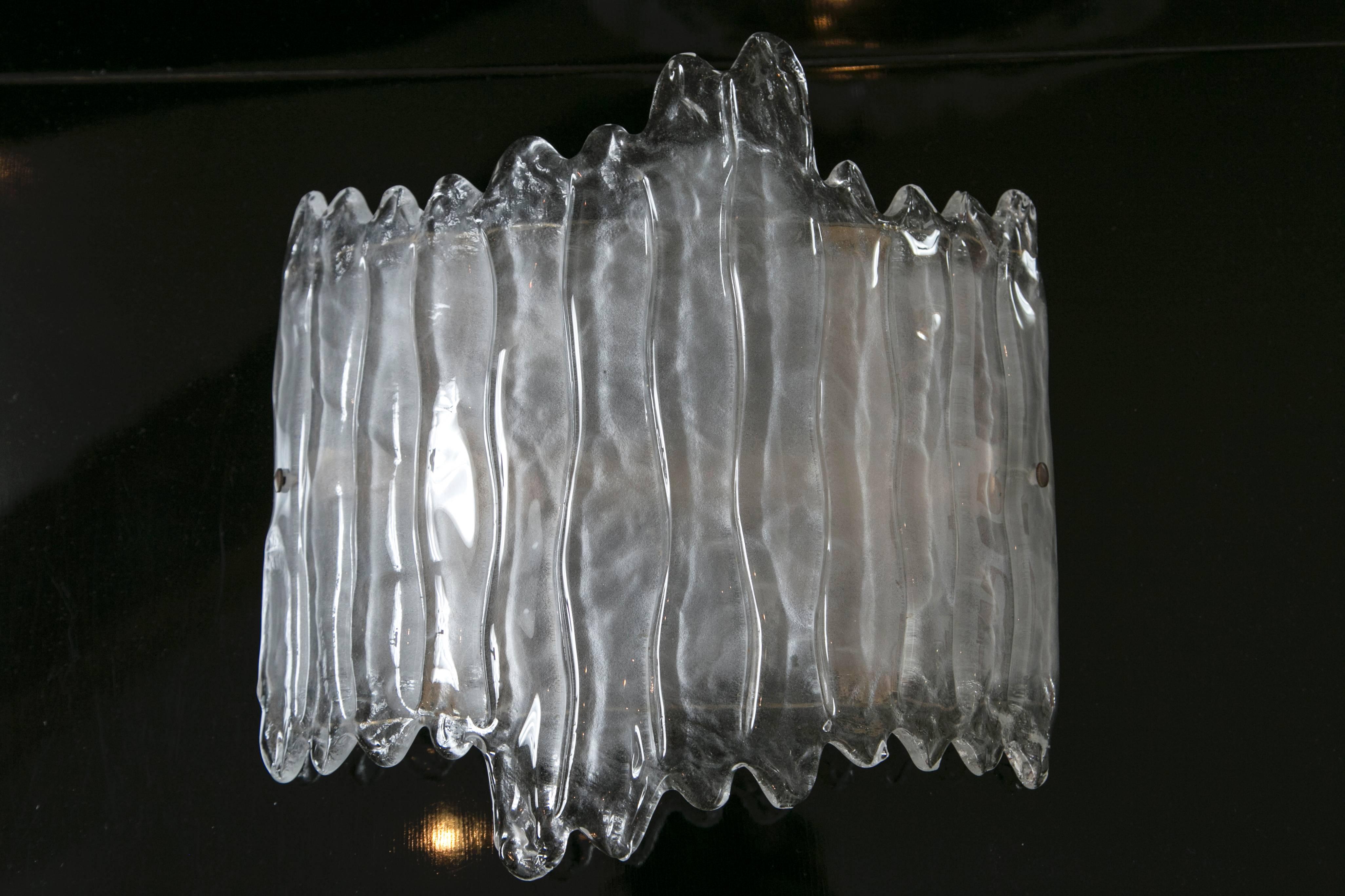 A dramatic and shimmery pair of curved demilune glass wall lights blown to appear as melting icicles, illuminated with 2 candelabra base sockets for up to 60 watts each
additional to UL certify
 