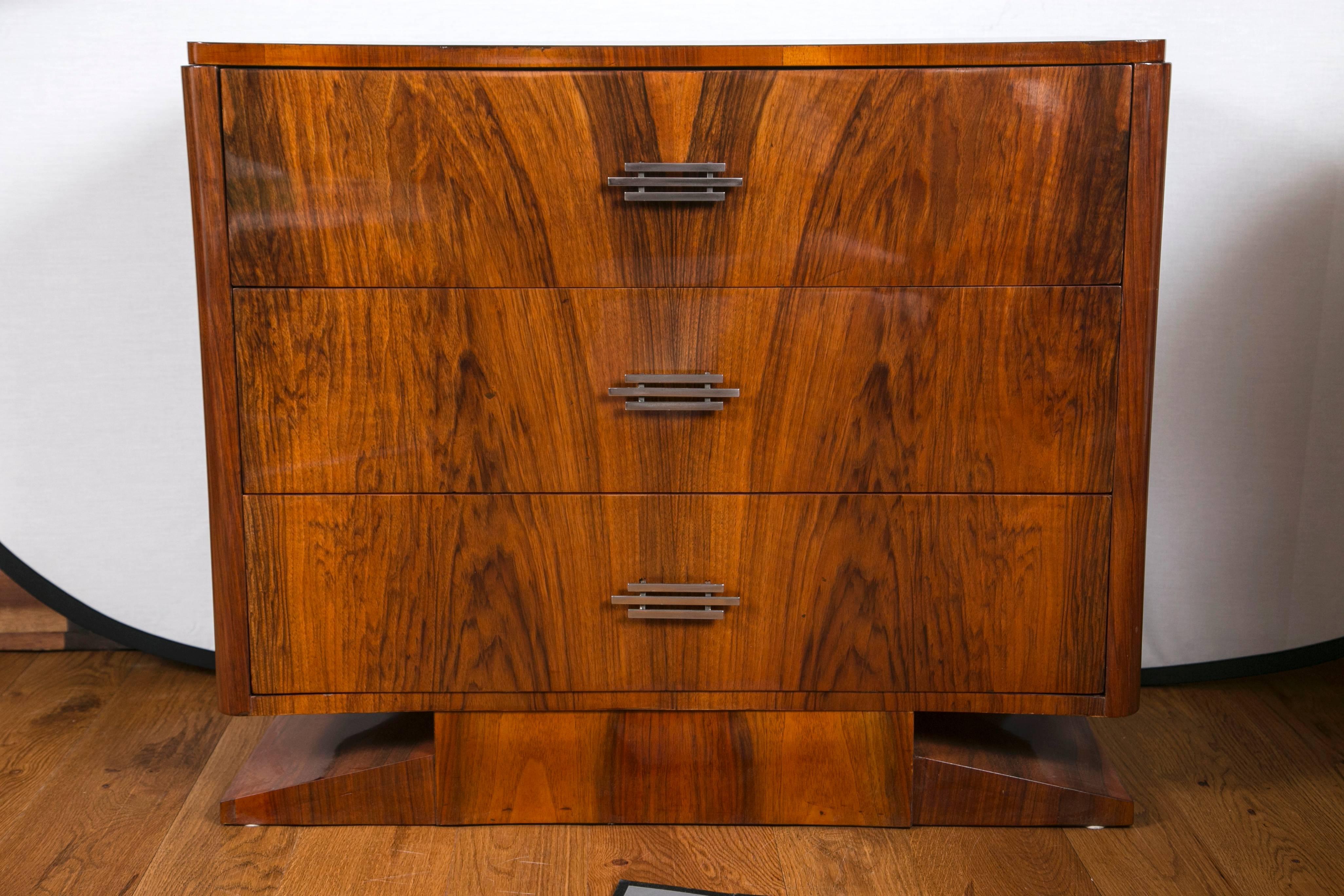 Handsome and unique sized smaller Art Deco chest of three drawers with rounded corners finishing on a pedestal base in Makassar veneer.
Recently refinished in lovely working condition.
