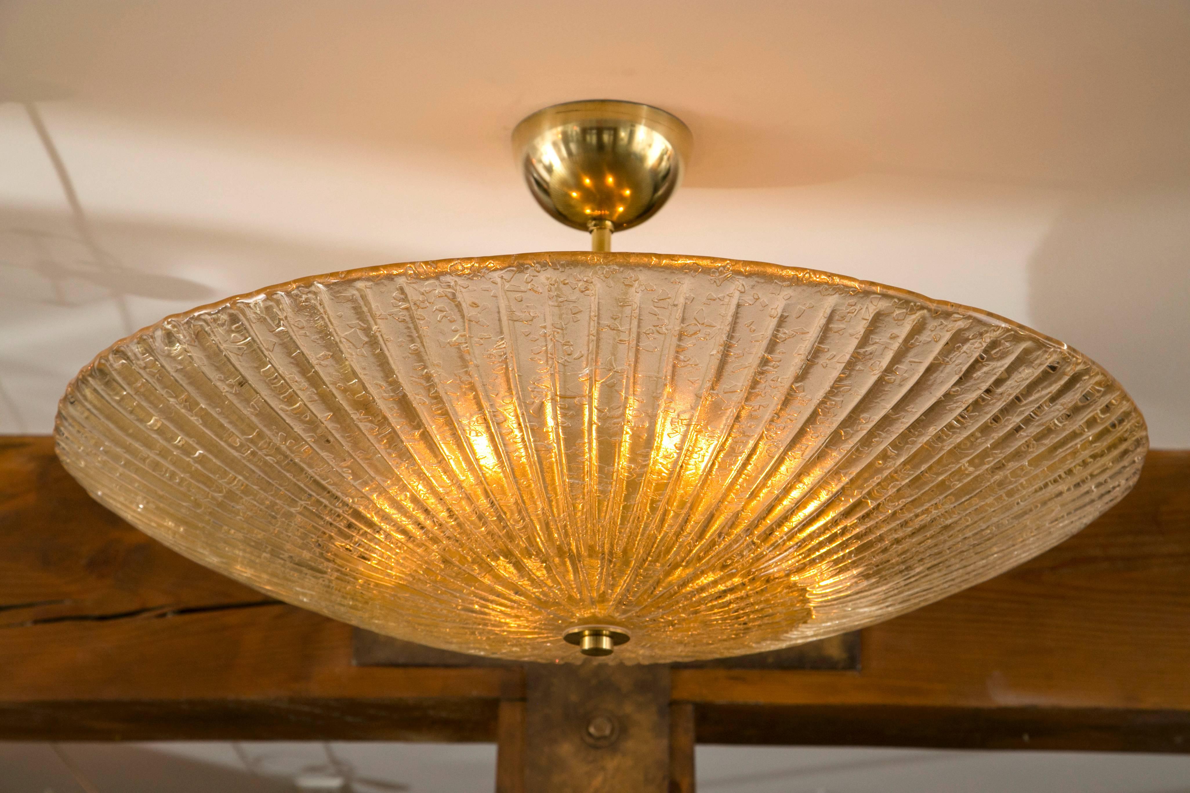 Circular-shaped and reeded Murano blown ceiling fixtures  blown in a champagne color with brass fittings.
Multiples available, priced individually.
Glass measure 32in dia, 8in high.
Installed height can be modified to a near flush